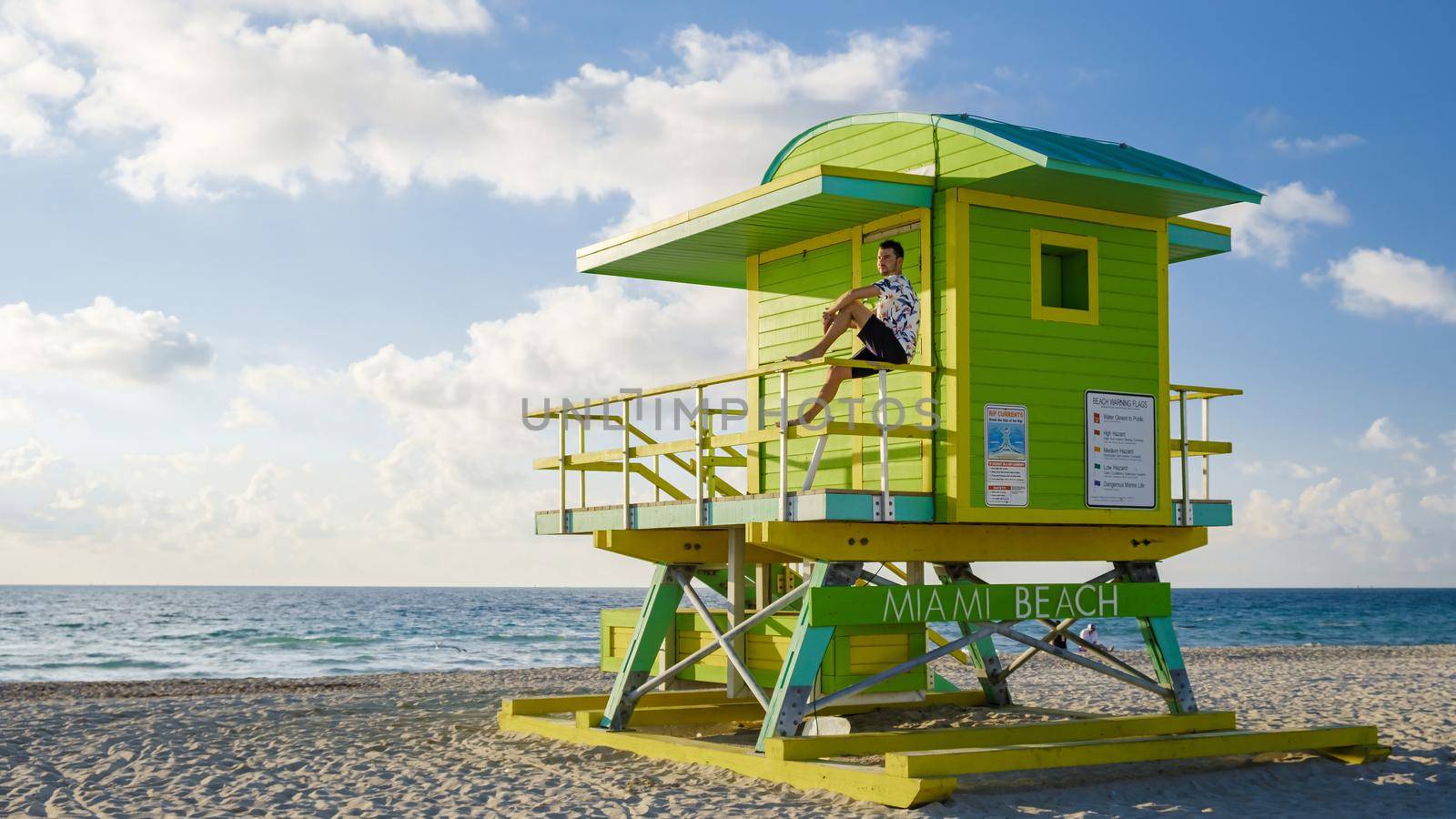 Miami beach, young men on the beach, lifeguard hut Miami beach Florida. caucasian men on the beach during sunrise. Caucasian men relax watching ocean