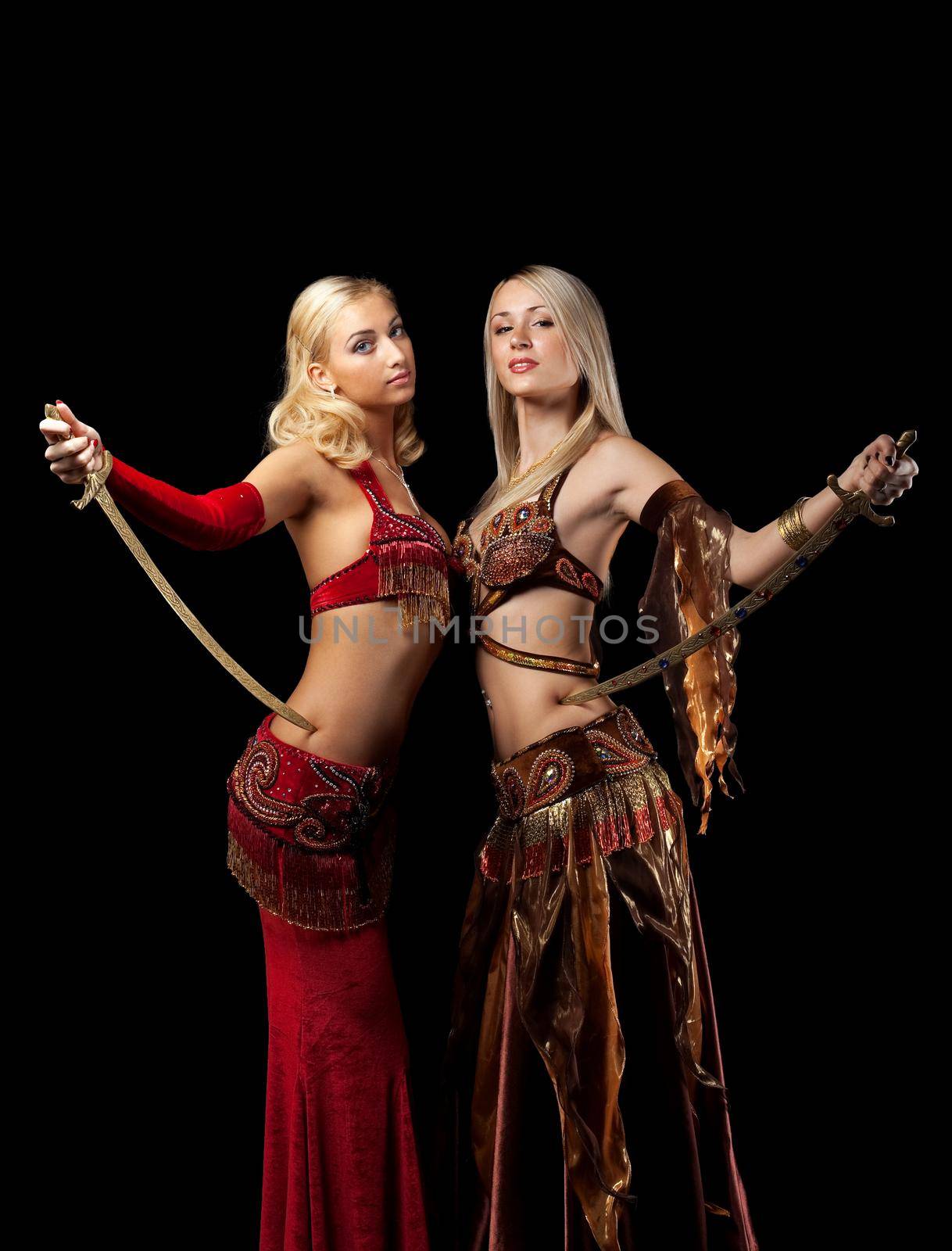 Two blond girl stand with saber - arabian traditional costume