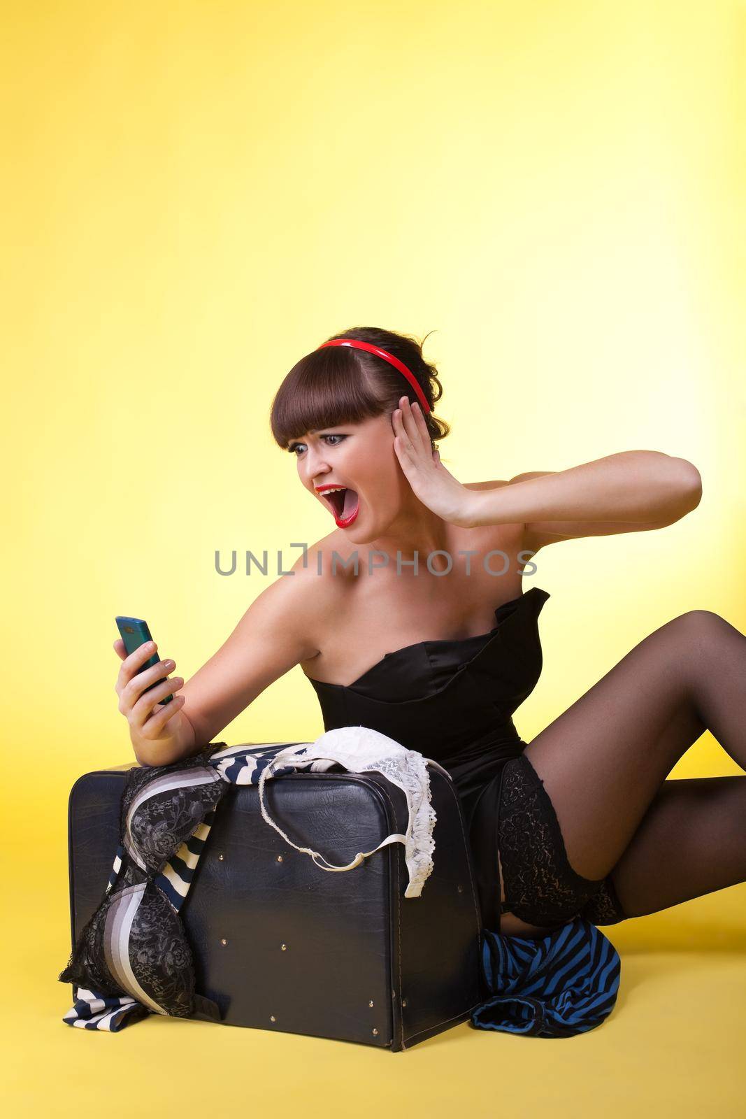 Young woman with broken baggage scream on cell - pinup
