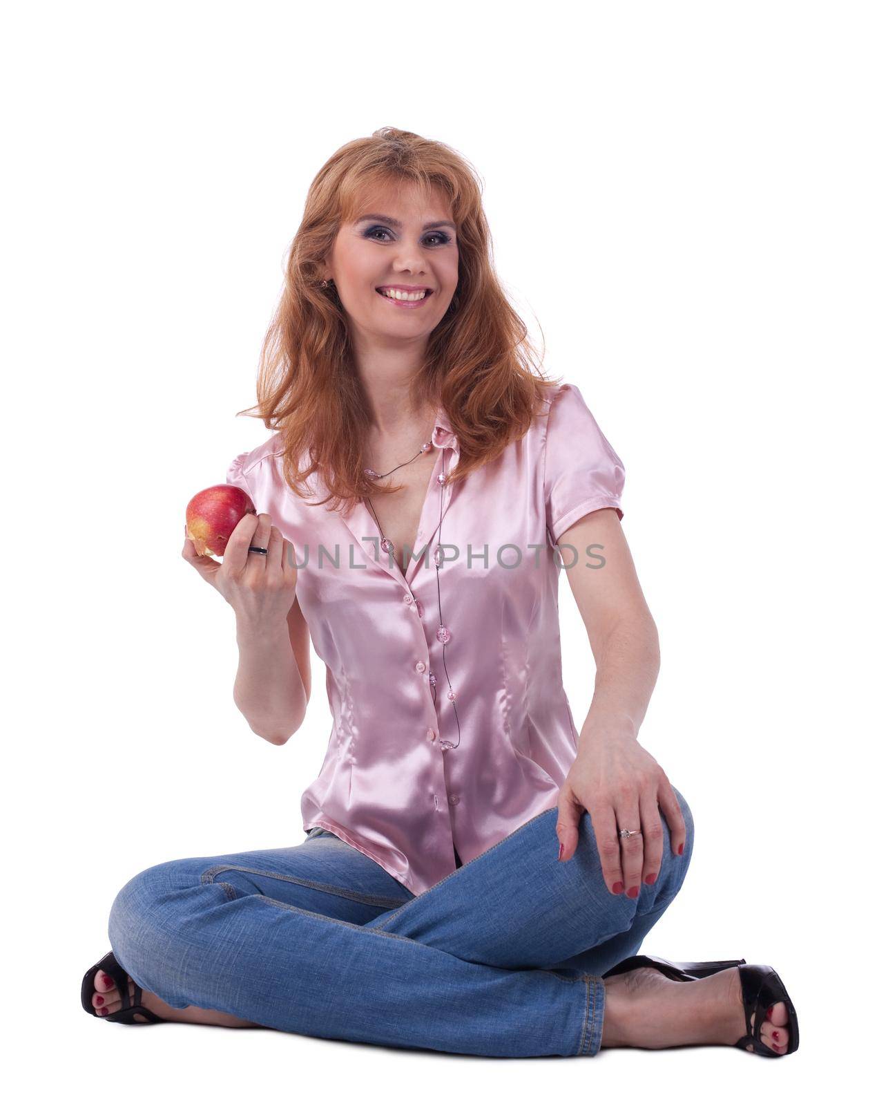 tall mature woman in jeans sit with apple isolated
