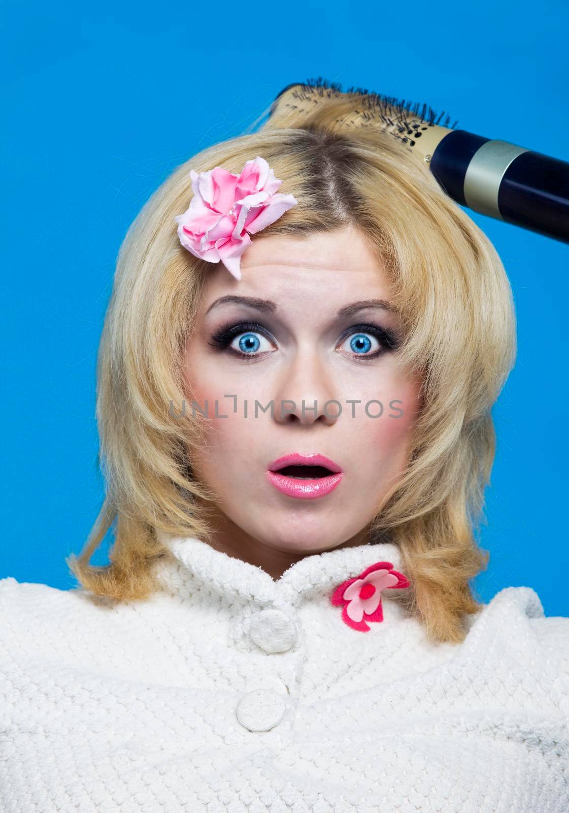 Young blond with hairdryer studio shot pin-up style