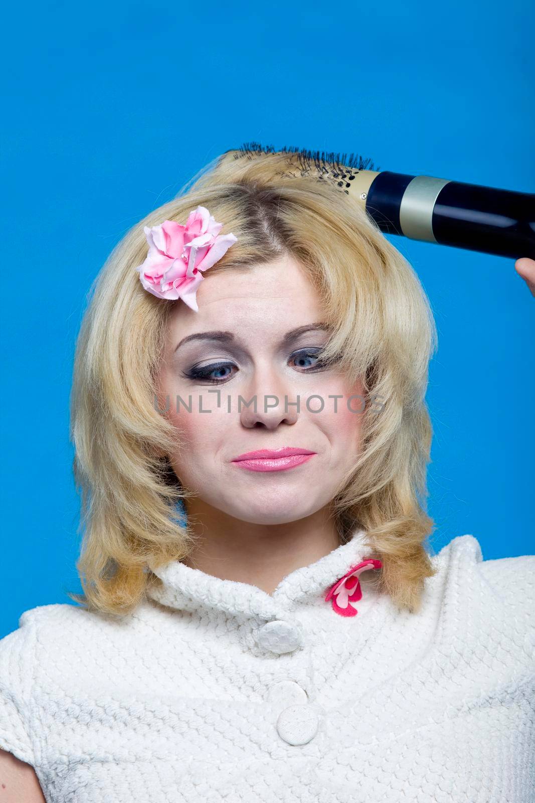 Young blond with hairdryer studio shot pin-up style