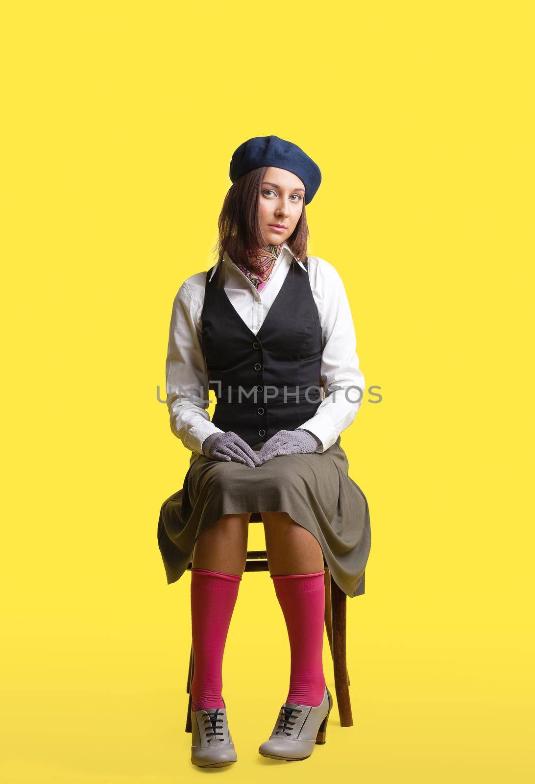 Girl in artist retro style cloth sit on yellow background