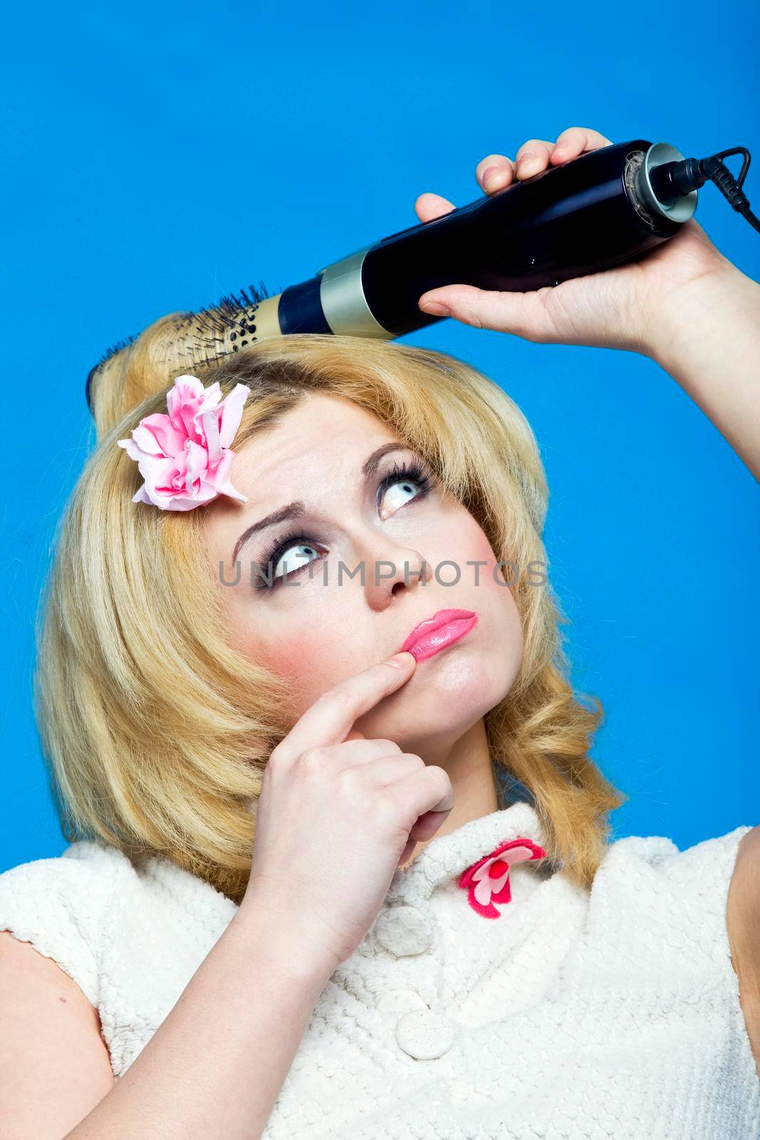 Young blond with hairdryer studio shot pin-up style