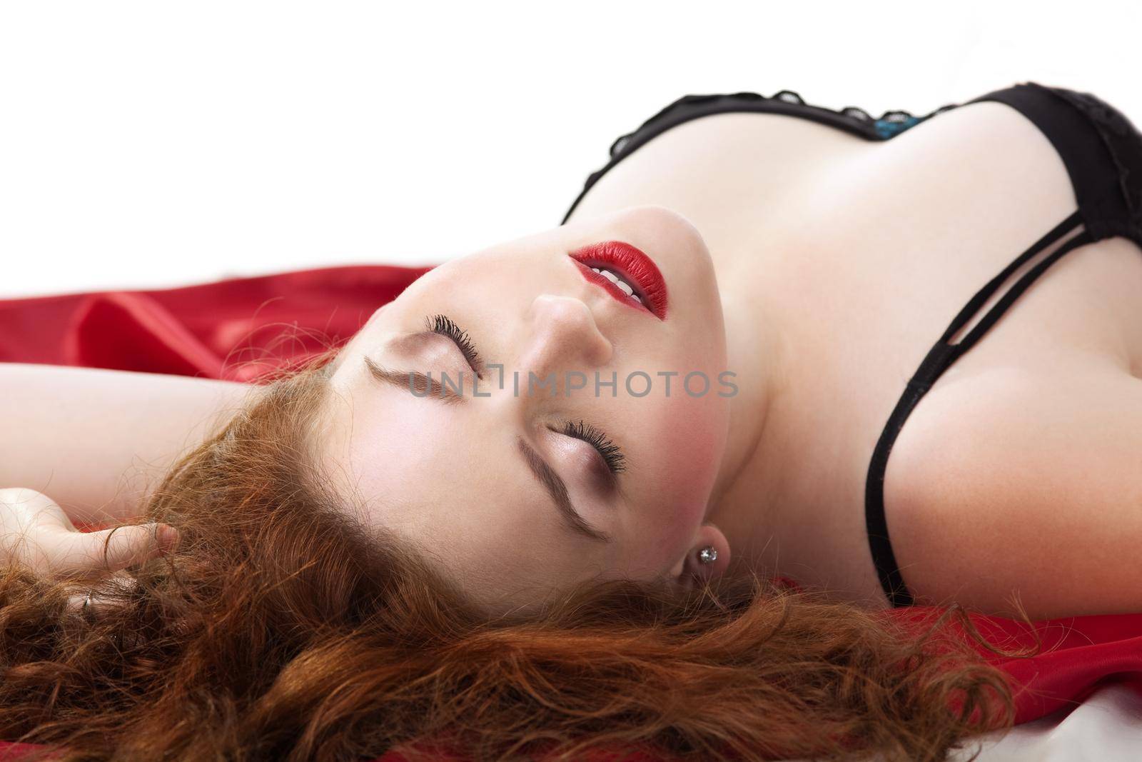 Beauty woman lay on red in lingerie in desire close eyes