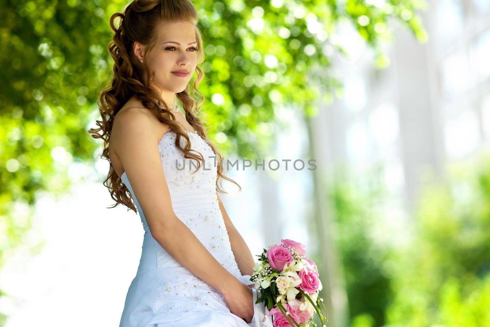 Beauty young bride with flowers in sunny summer day