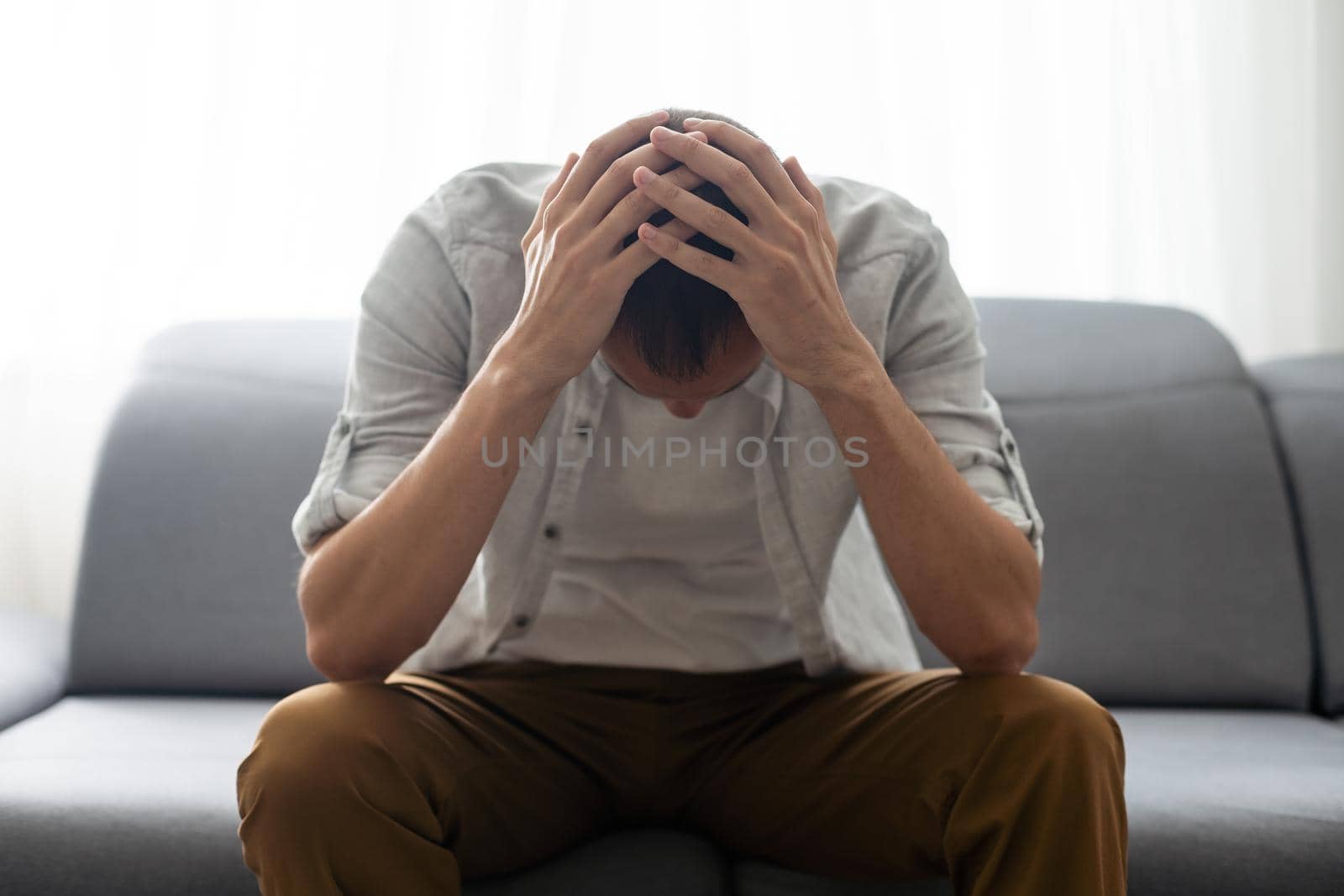 Man On Sofa Having Headache