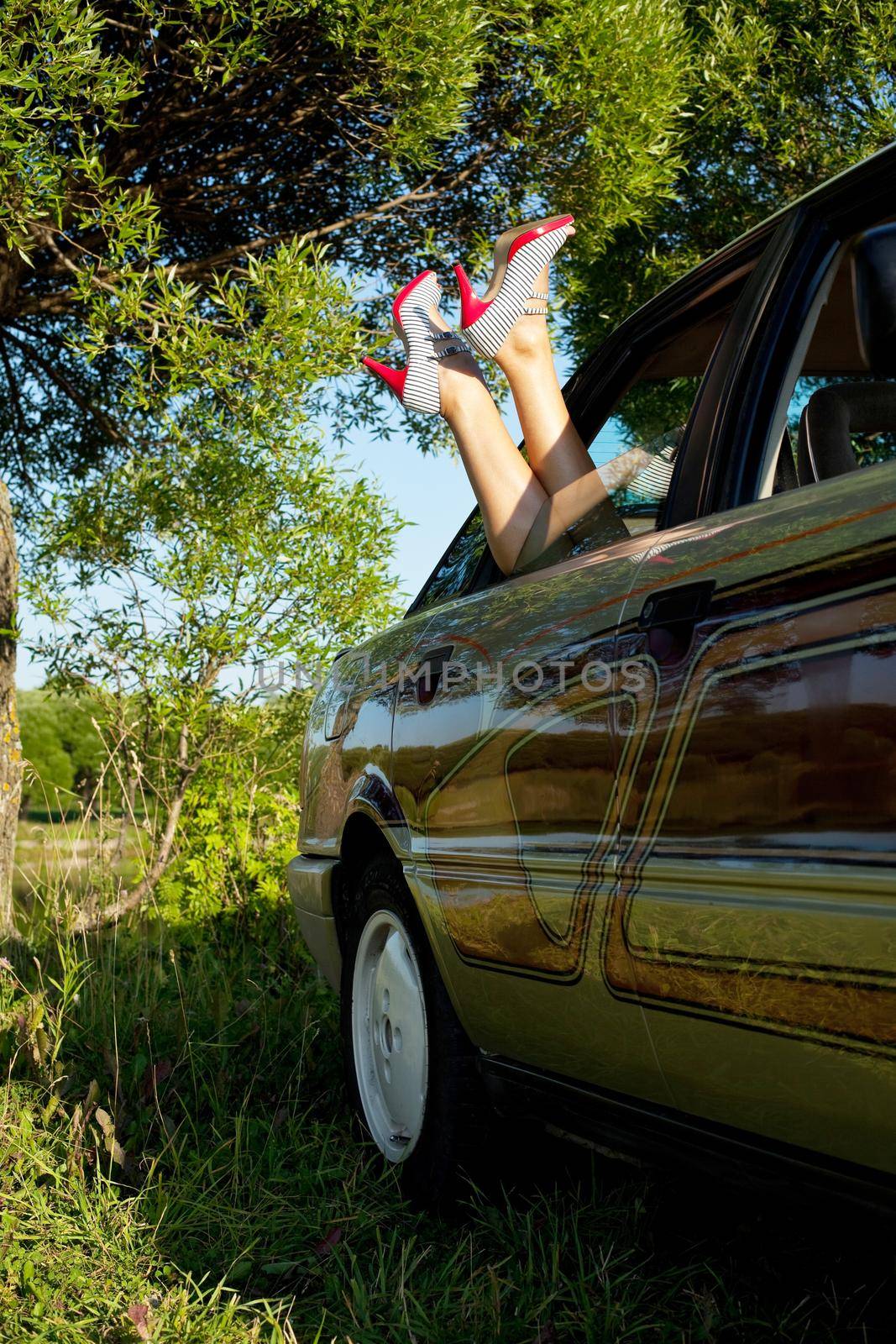 Young sexy woman lay in car legs out by rivertime