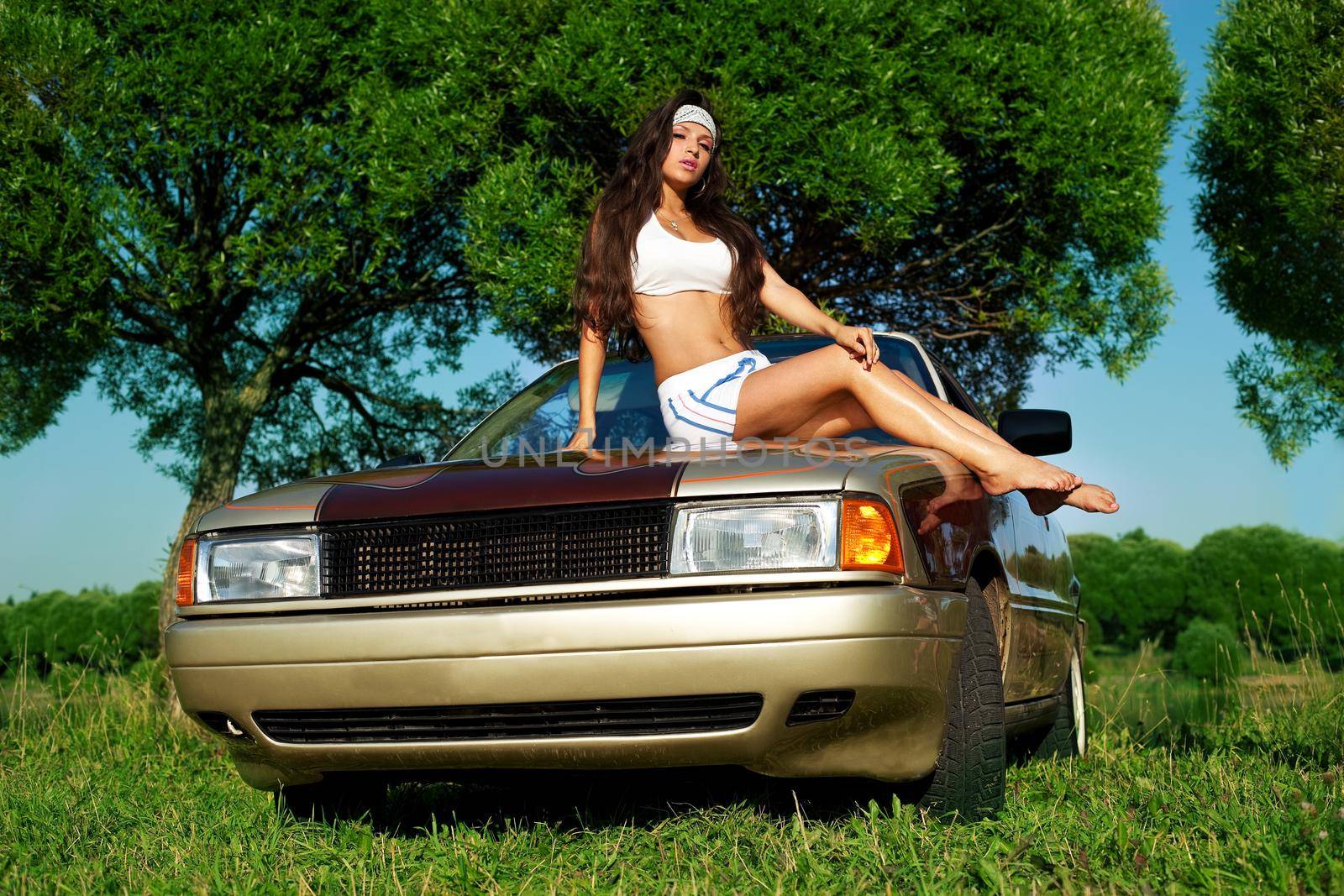 Beauty young girl washing a car at summer sunset by rivertime