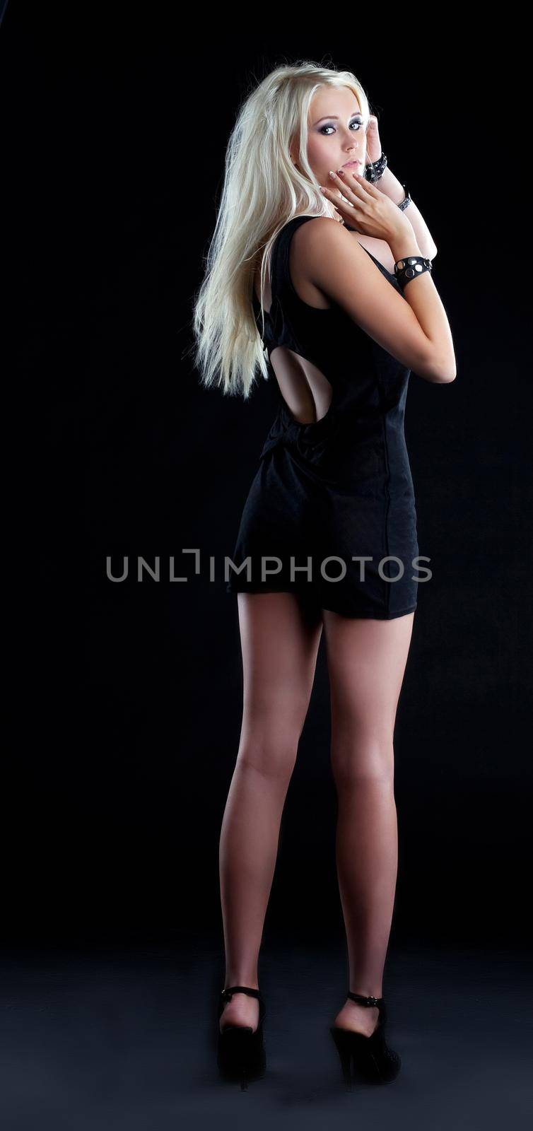 Amazing blond girl in black short cloth in dark