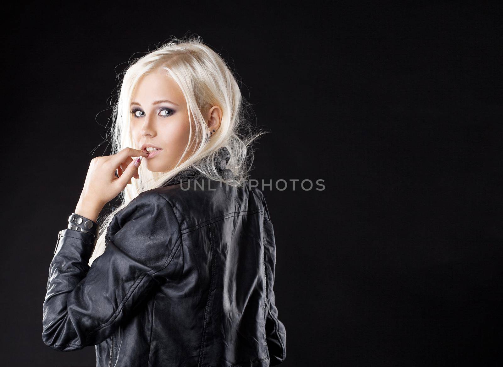 Pretty young blond girl look at camera with desire in leather