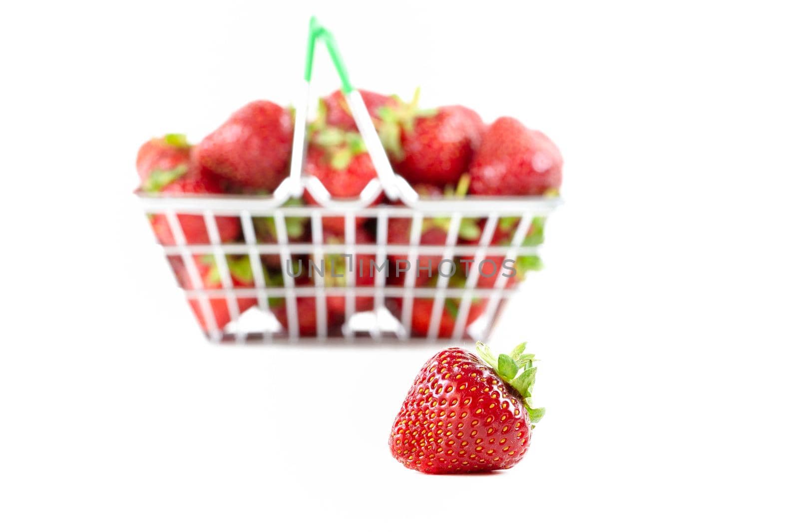 Fresh ripe strawberries in a mini shopping trolley isolated on a white background. Concept of a supermarket, market, or grocery store. copy space.