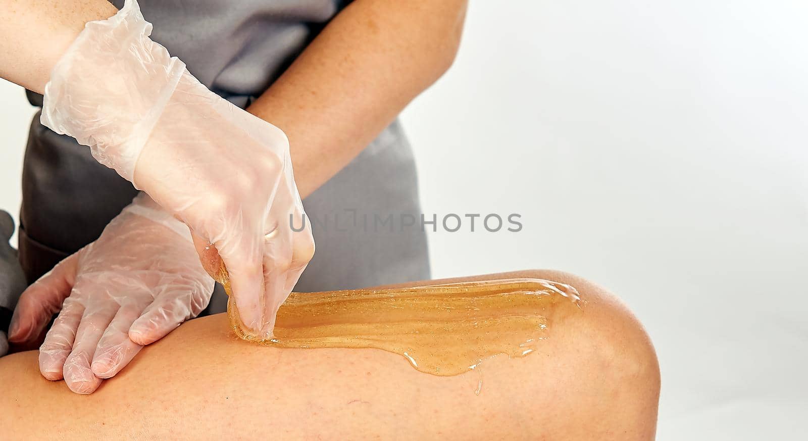 Sugar paste for light depilation. Depilation with sugar paste in the salon on a white background.