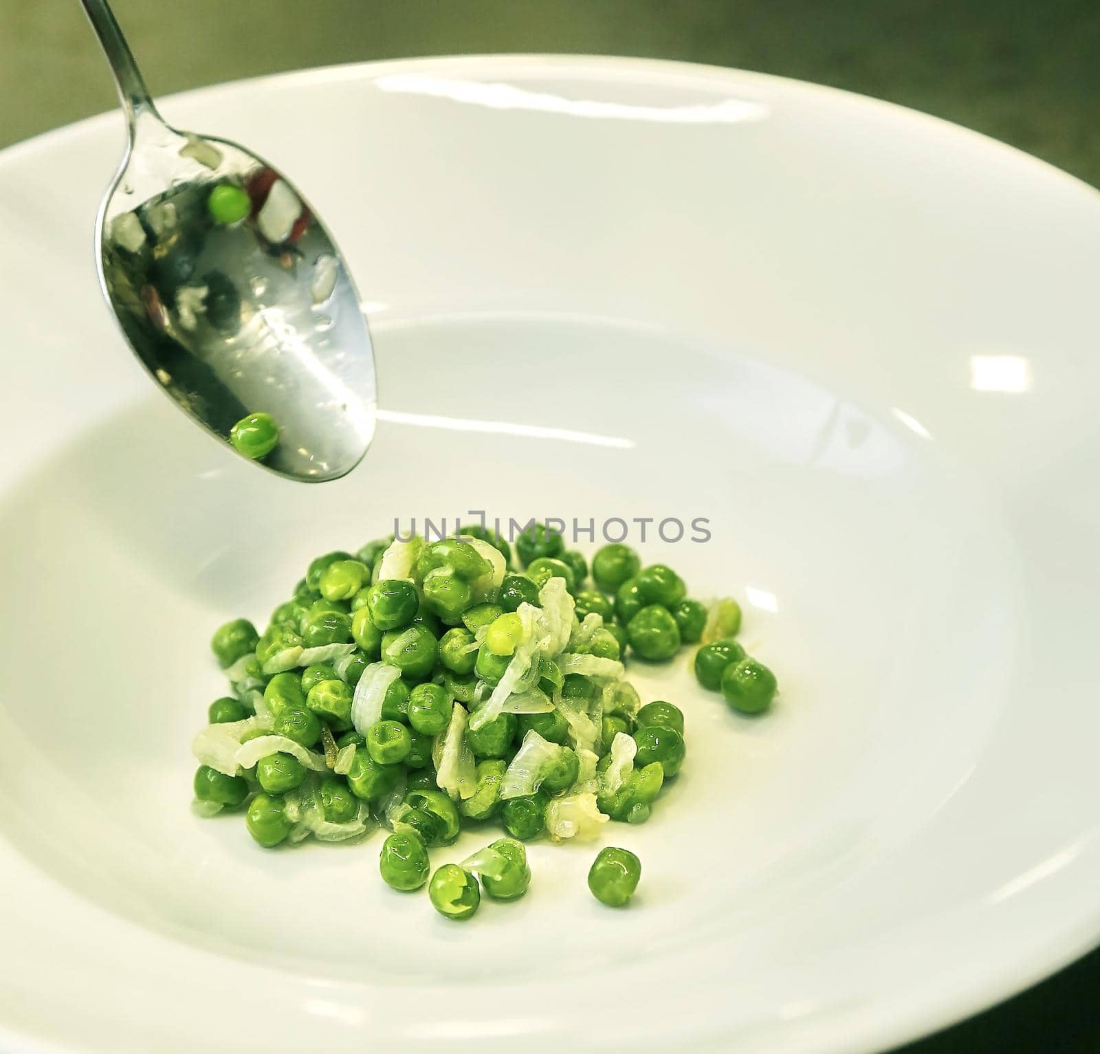Green peas in the kitchen in a pan. Preparing a side dish for dinner.