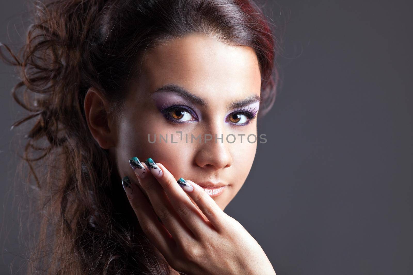 Attractive young brunette woman close-up portrait on grey