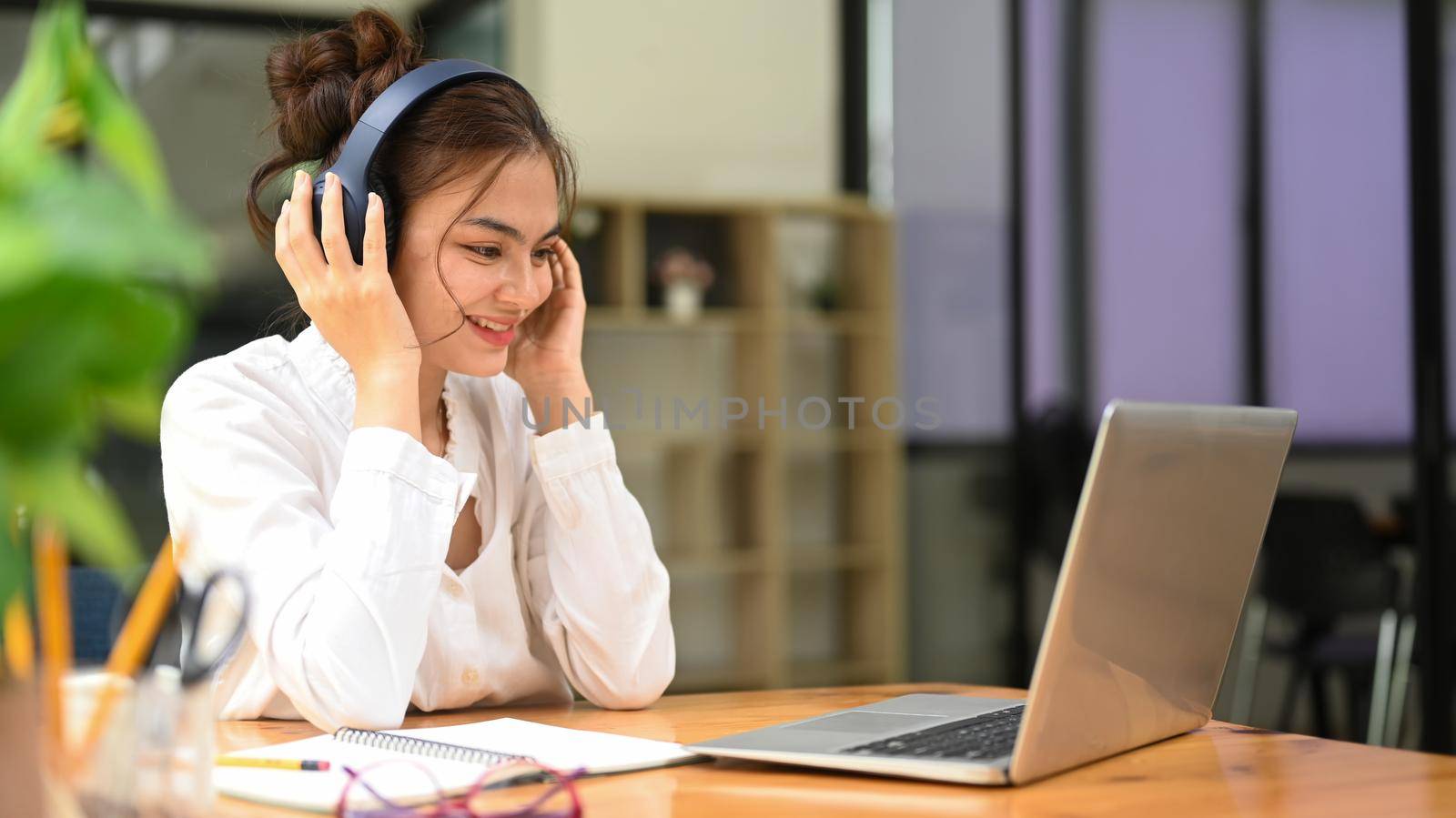 Pretty young woman, chatting online, listening lecture during study online on laptop. Education, e-learning, distance training concept by prathanchorruangsak