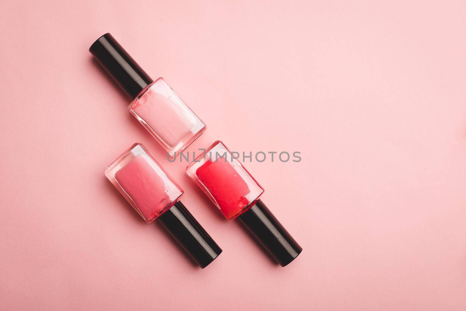 Pink nail polish on a pink copy space background. An article about nail polishes. Gel polish. An article about cosmetics. Decorative cosmetics . Pink background