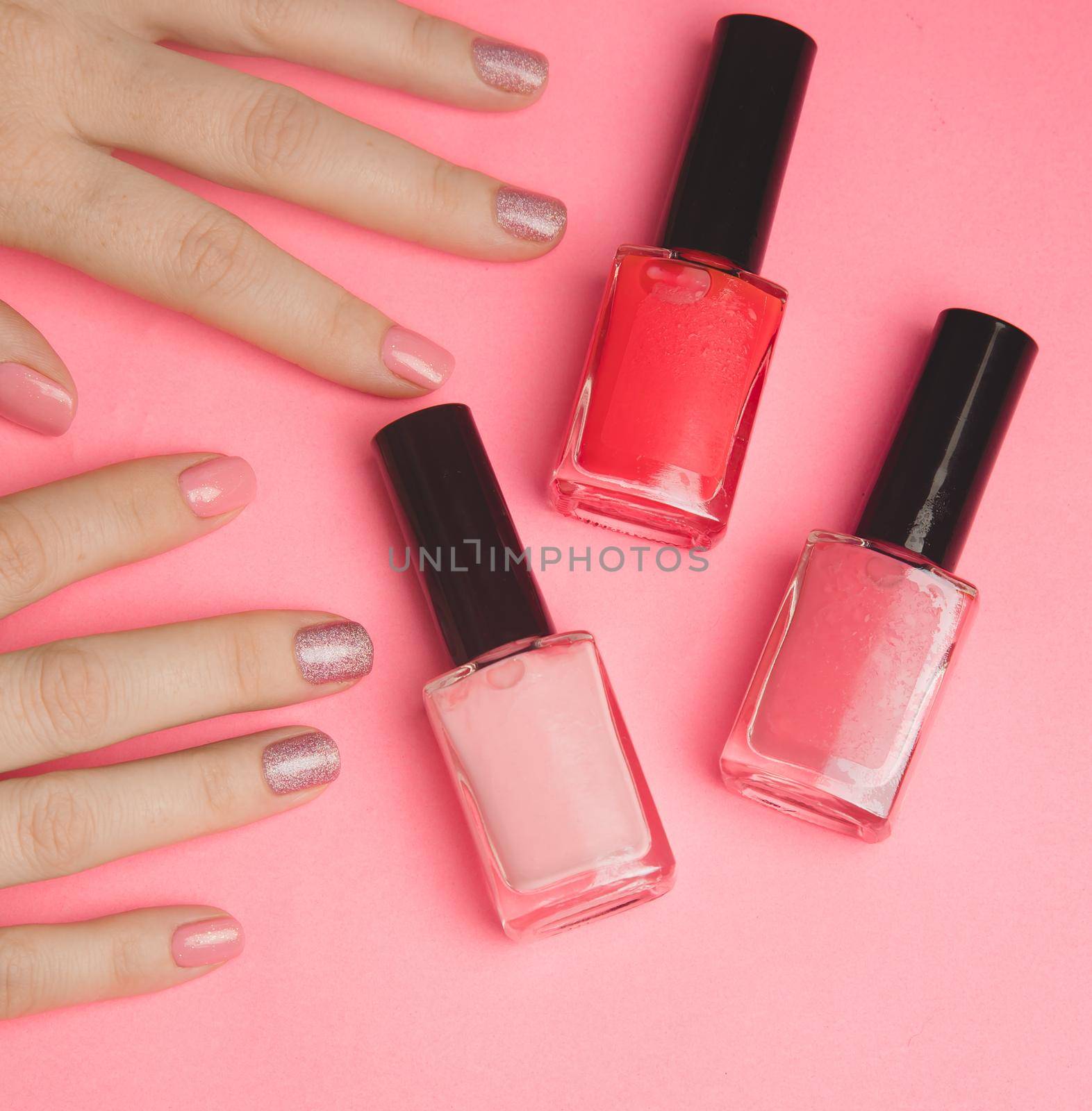 Nail polish in a woman's hand copy space. Article about manicure. Gel polish. Hand care . Pink background