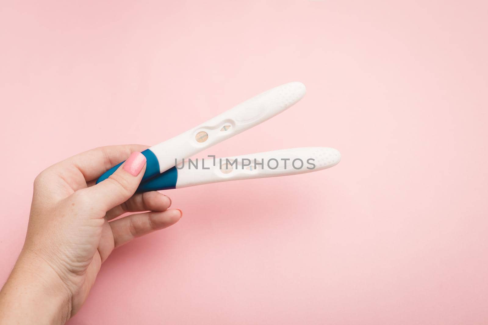Pregnancy test in hand on a pink background . Positive test. Pregnancy copy space. by alenka2194