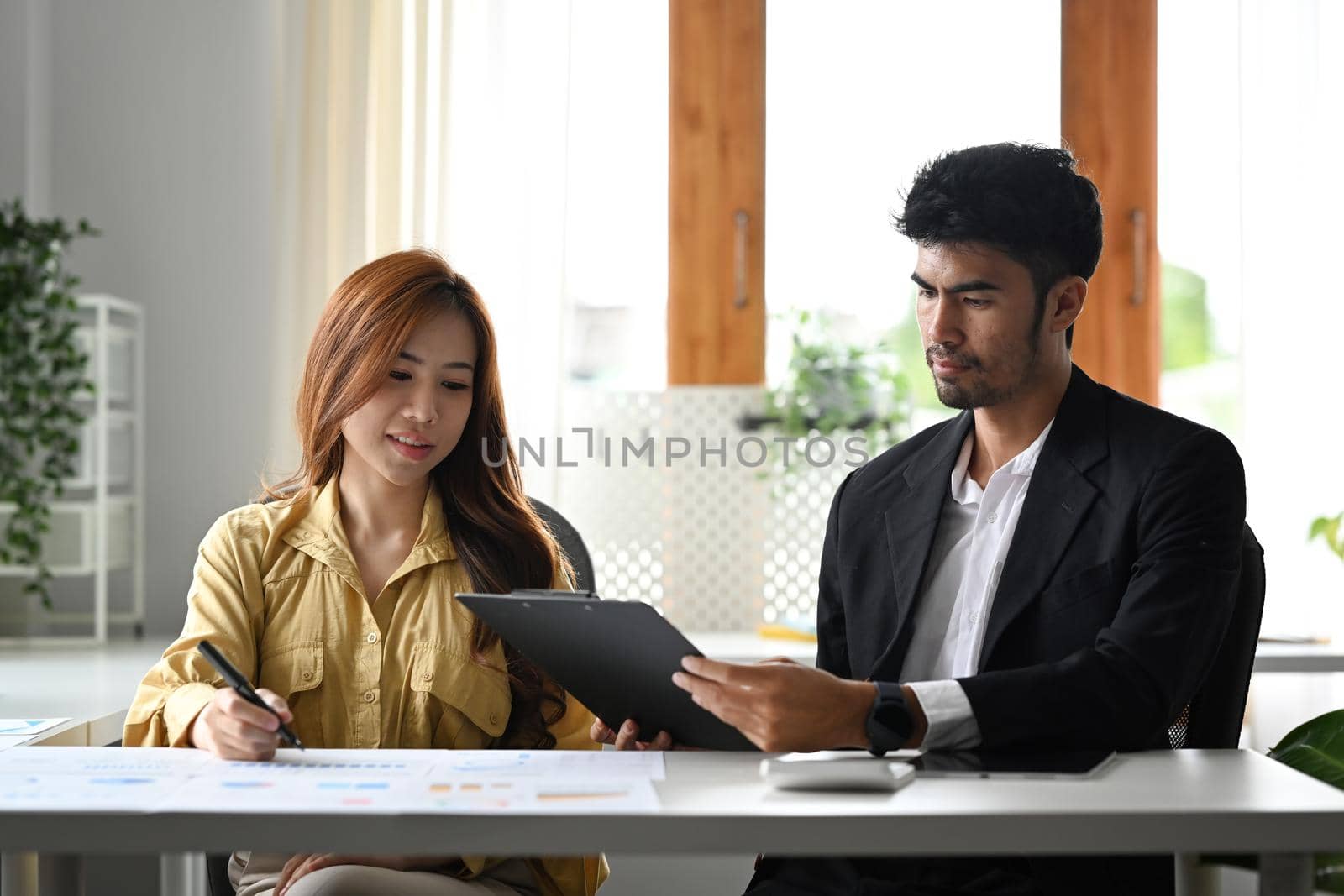 Professional businesspeople sharing ideas or startup business plan together at contemporary office by prathanchorruangsak
