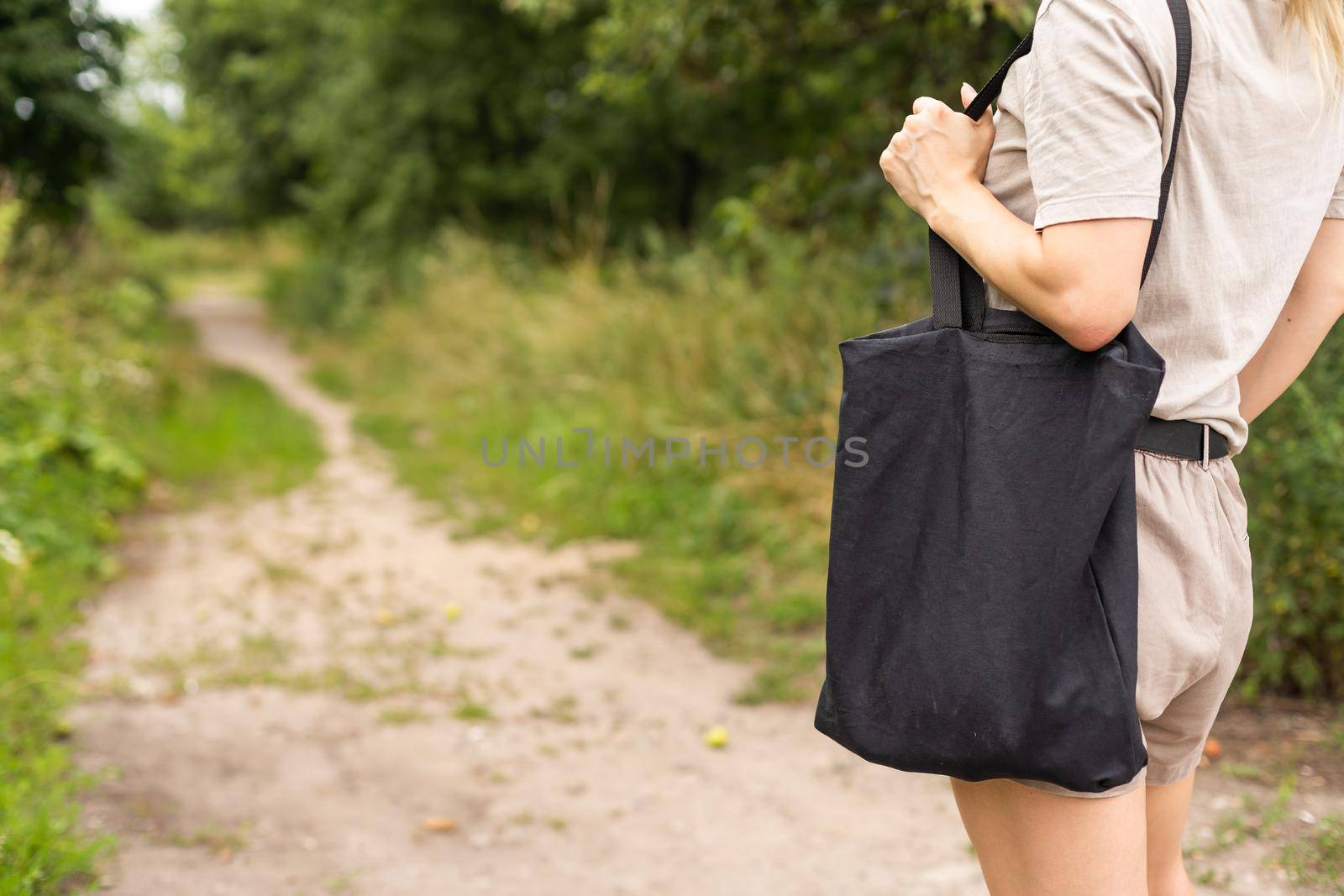 Girl is holding black cotton eco tote bag, design mockup.