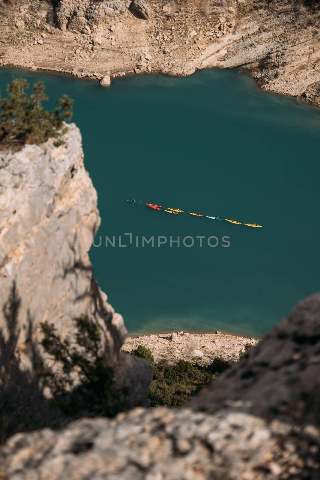 Several kayaks float on the emerald lake in the mountains. View from above. Congost de Mont Rebei, Catalonia, Spain.