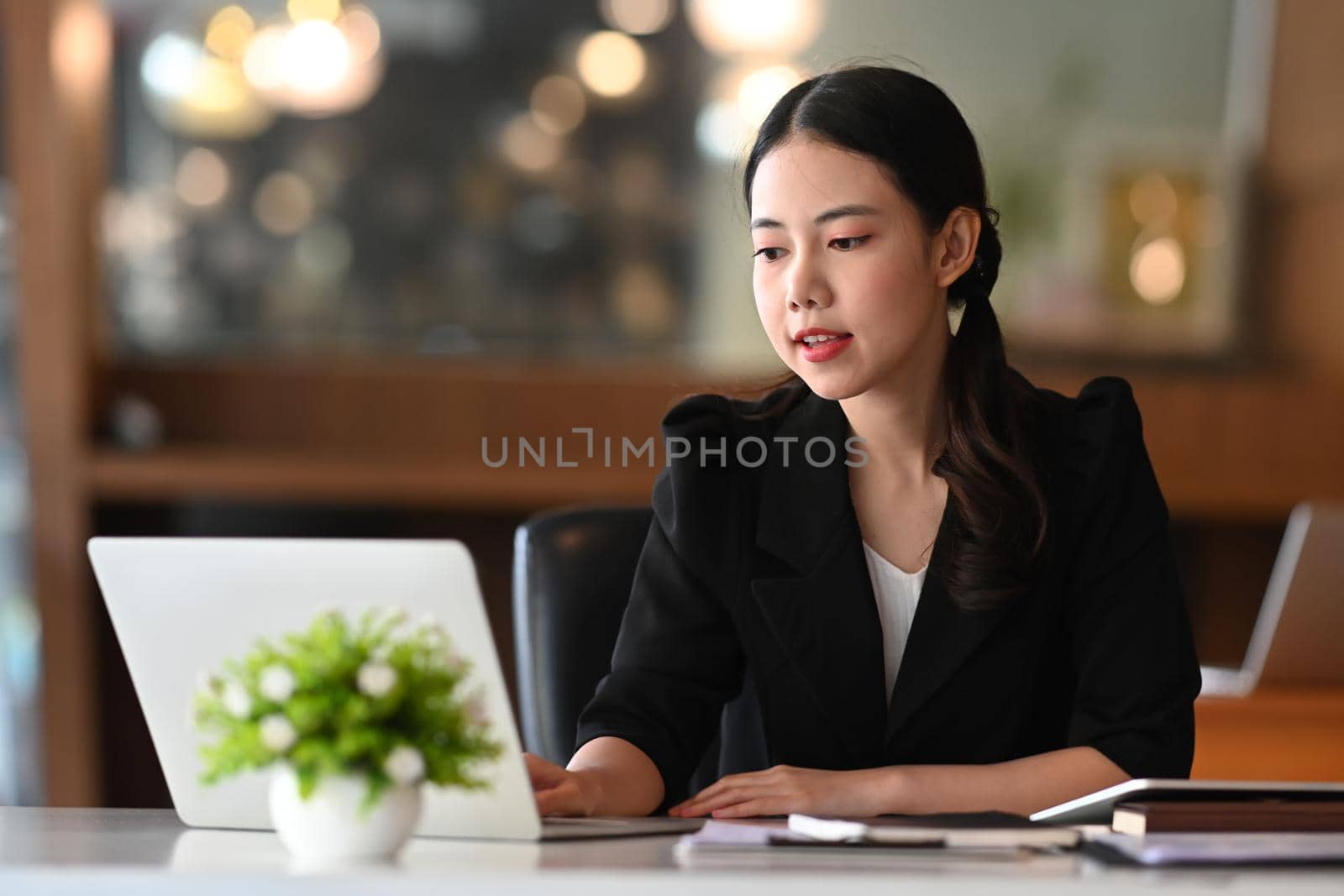 Thoughtful businesswoman working with laptop computer. by prathanchorruangsak