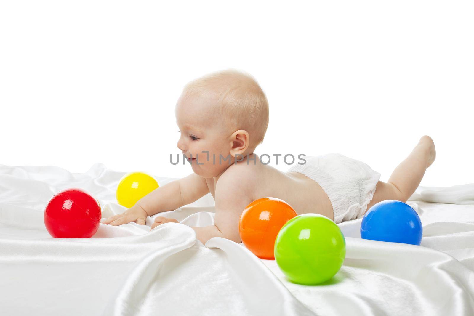 Cute baby play in bed with color balls isolated