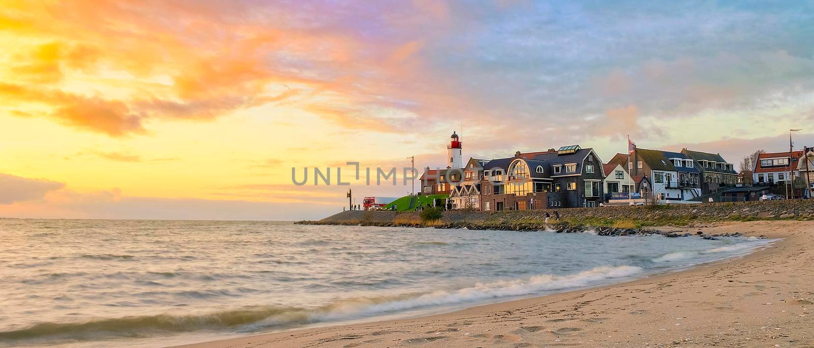 Urk Flevoland Netherlands sunset at the lighthouse and harbor of Urk Holland. Fishing village Urk. Beautiful sunset drone aerial view