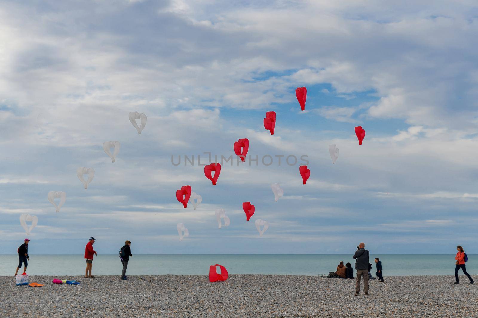 DIEPPE, FRANCE - SEPTEMBER 08, 2018: Red and white kites hearts are flying in the wind at the festival of kites