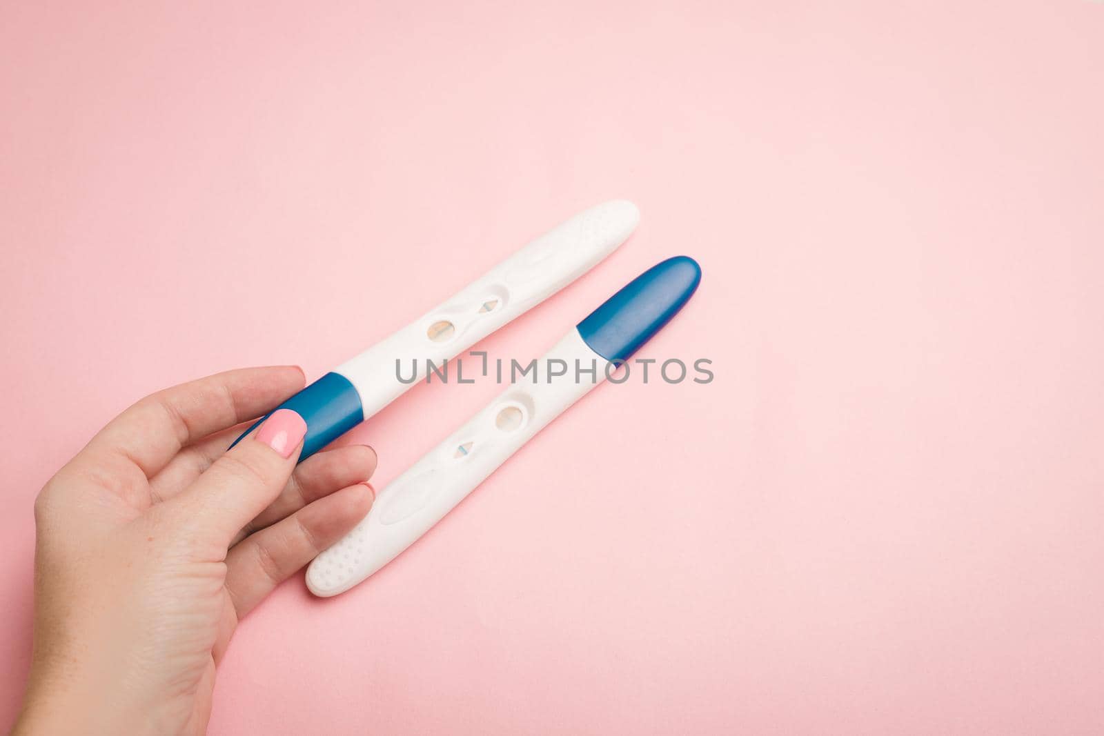 Pregnancy test in hand on a pink background . Positive test. Pregnancy copy space. by alenka2194