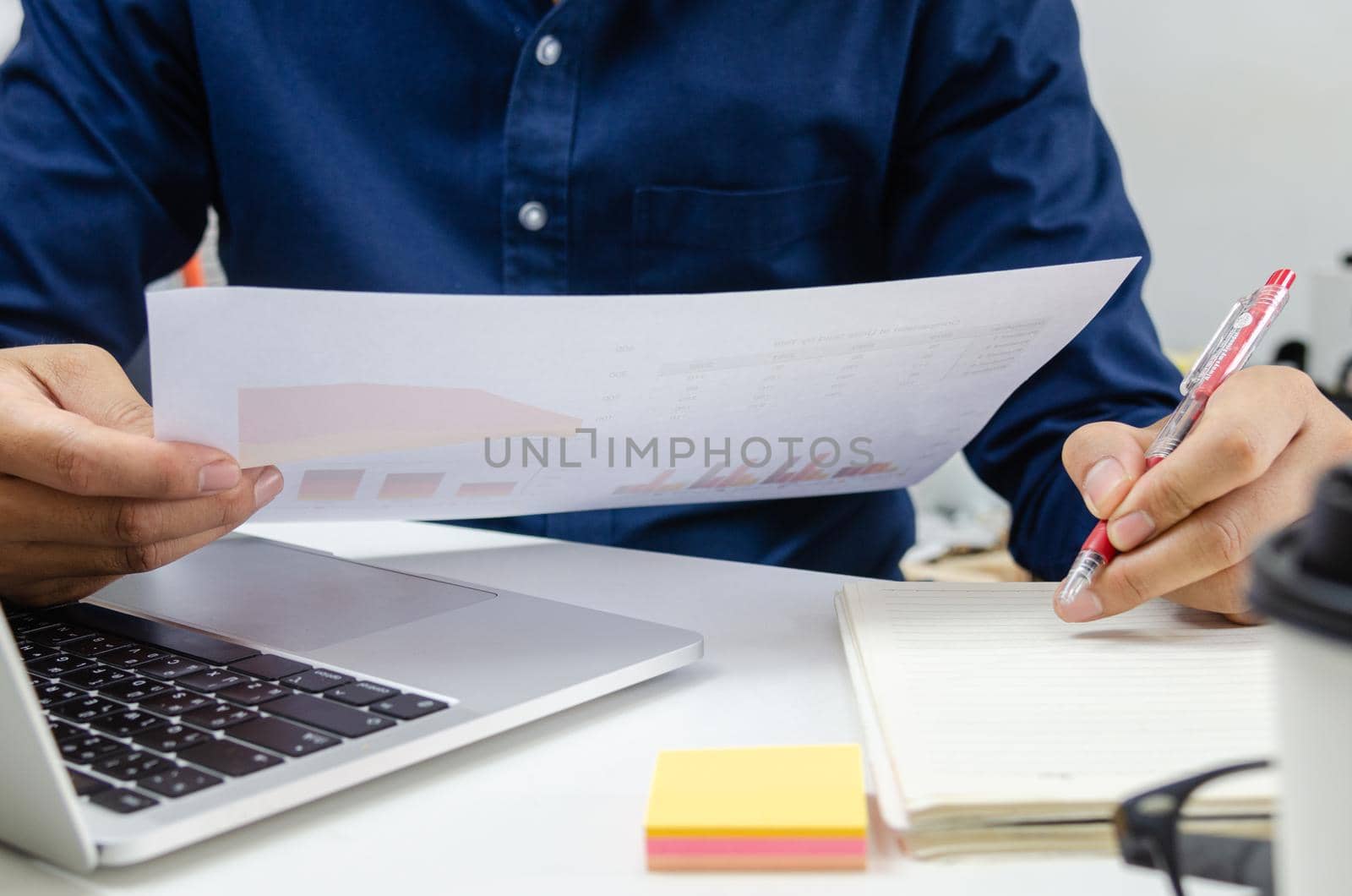 Businessman holding paperwork document graph report accounting and finance investment on desk by aoo3771