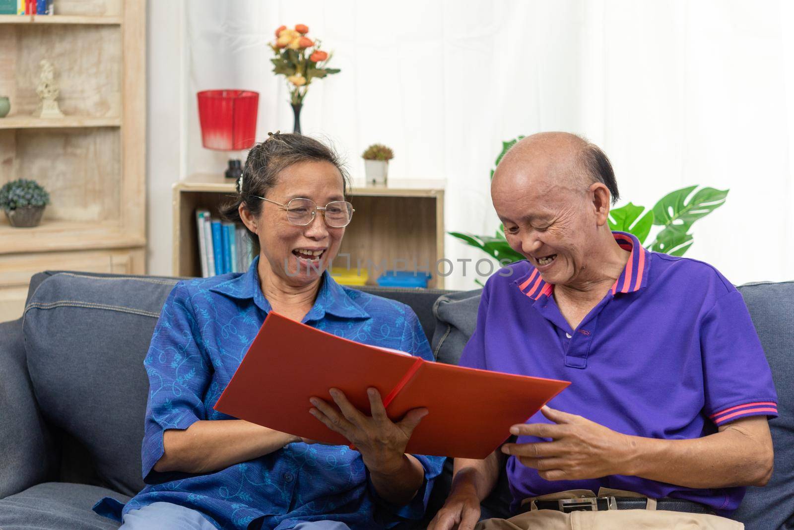 Senior asian couple talking happy planing retirement insurance health care contract on sofa.