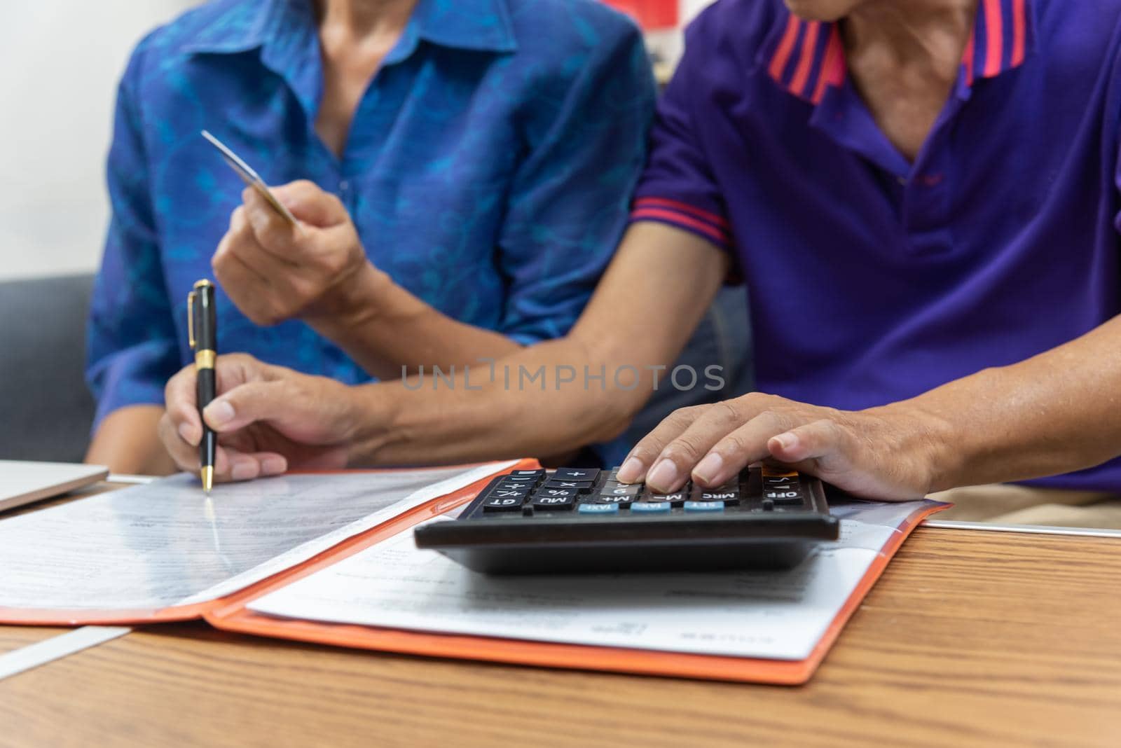 Asian elderly holding pen contract payment credit card insurance health care paperwork or document report shopping finance concept.