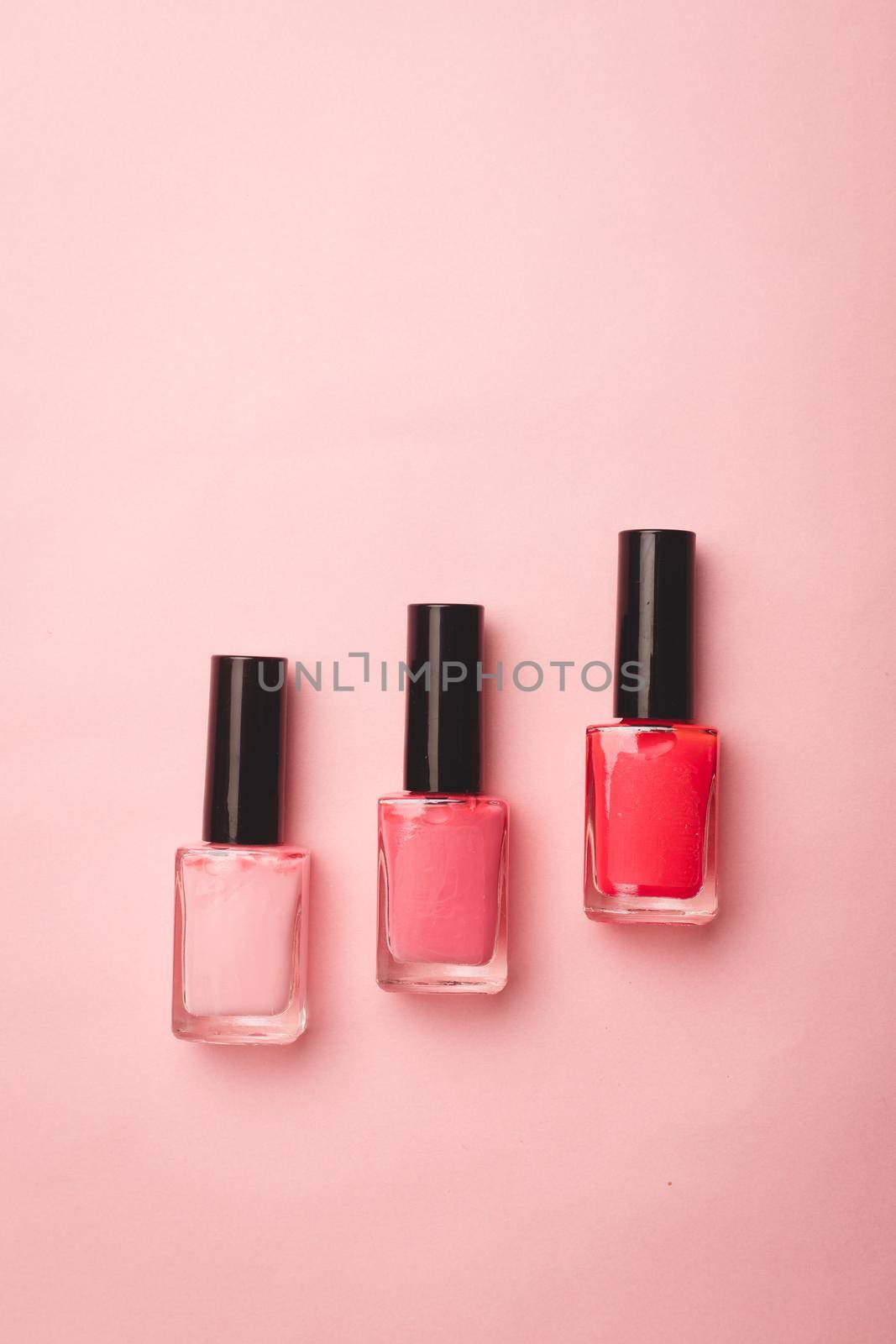 Pink nail polish on a pink copy space background. An article about nail polishes. Gel polish. An article about cosmetics. Decorative cosmetics . Pink background