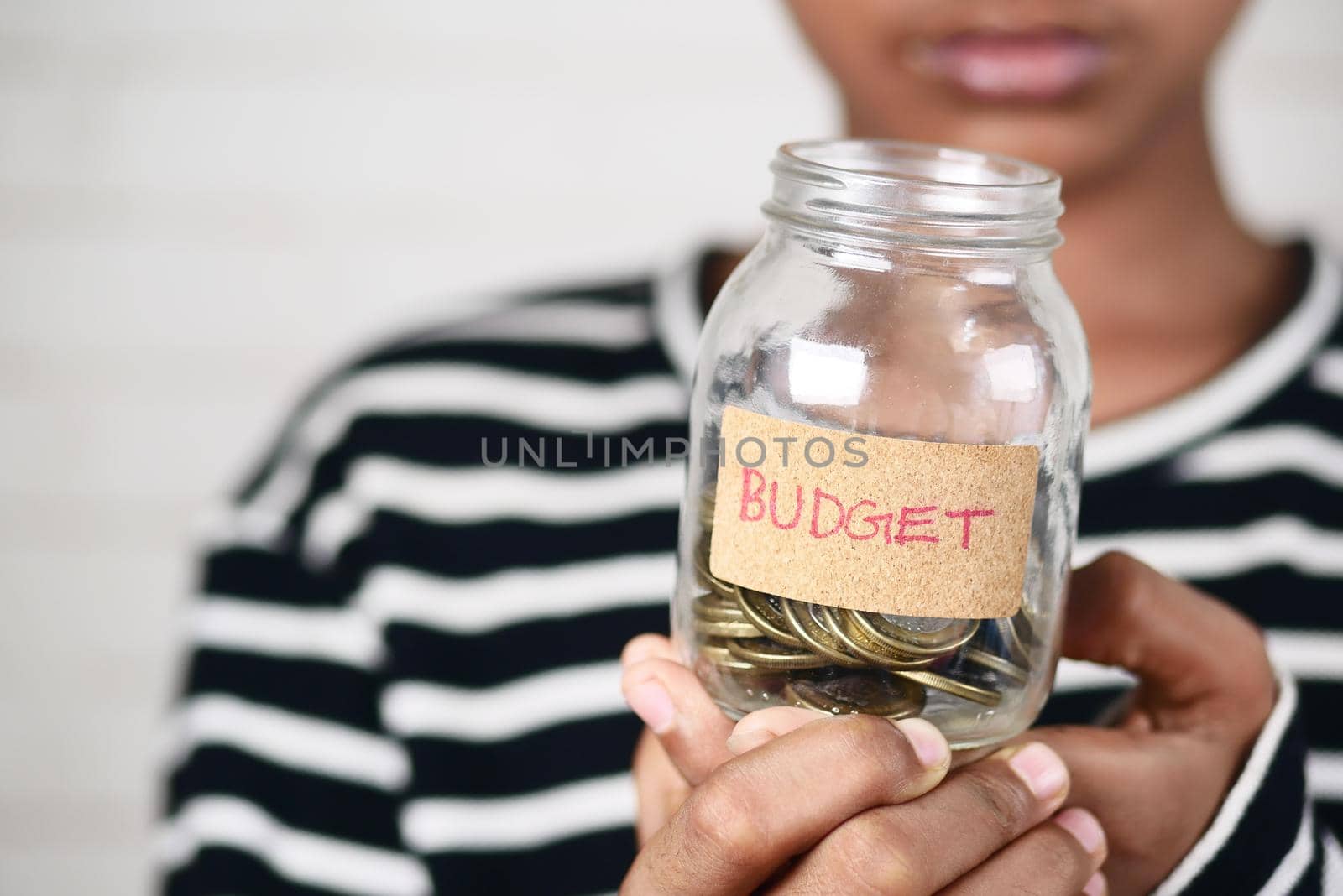 boy holding a coin jar with budget text ,