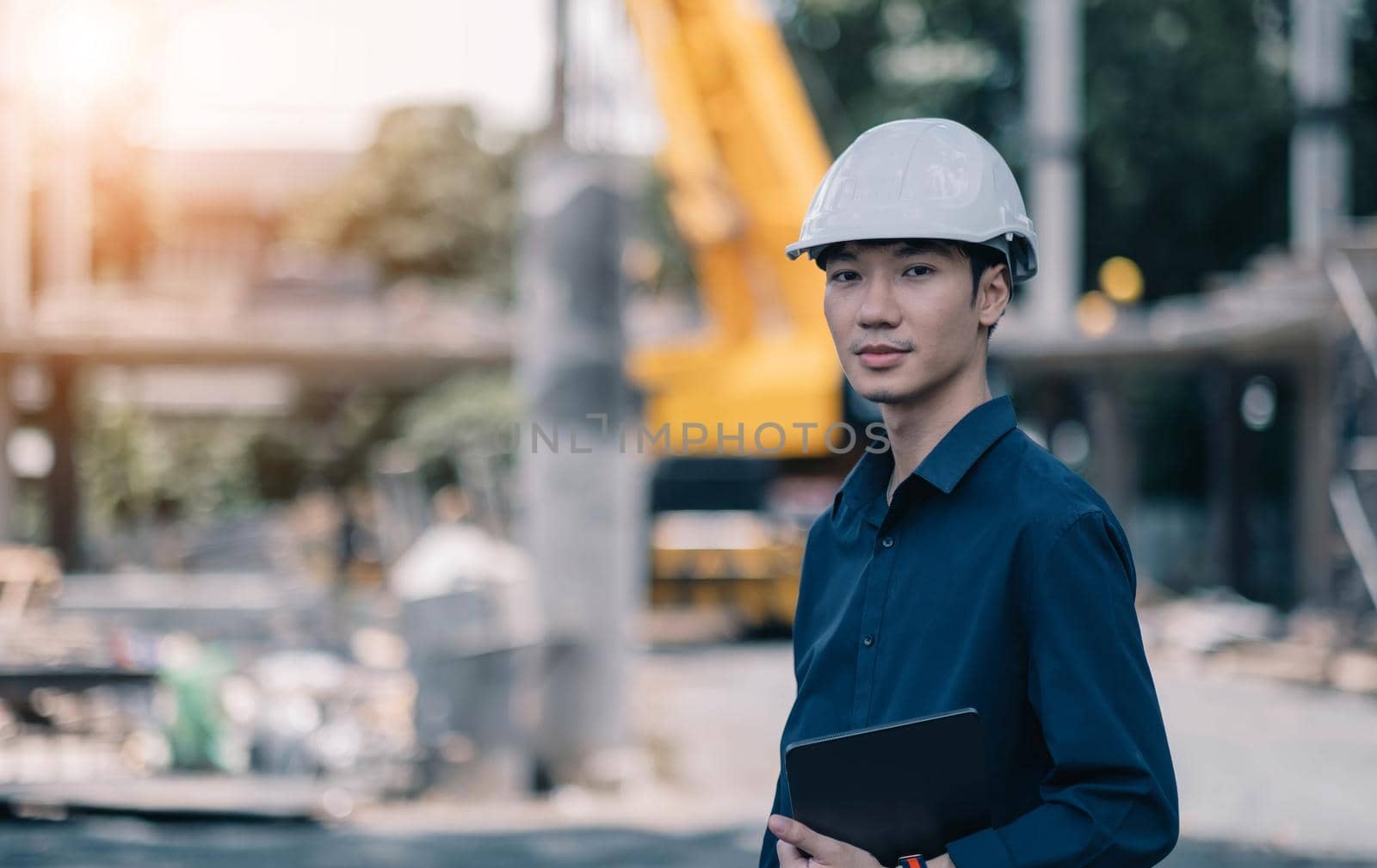Handsome Male foreman engineer wearing helmet controls and maintains the operation project system. by wichayada