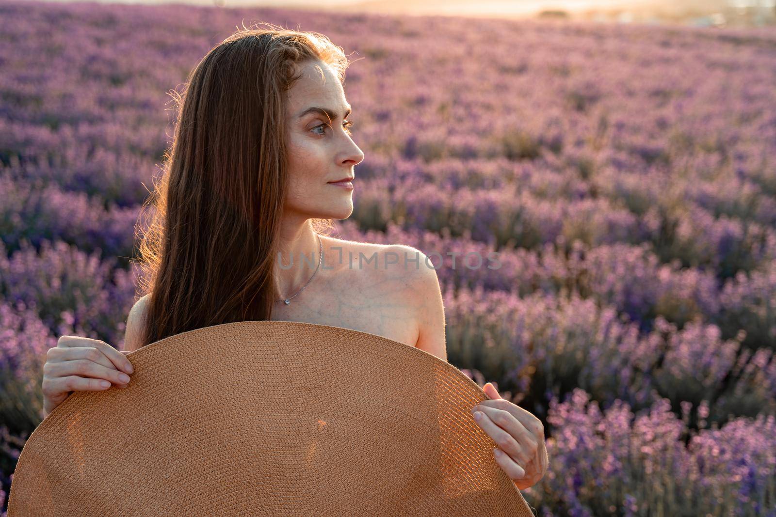 Beautiful woman in a lavender field at sunset. Soft Focus.