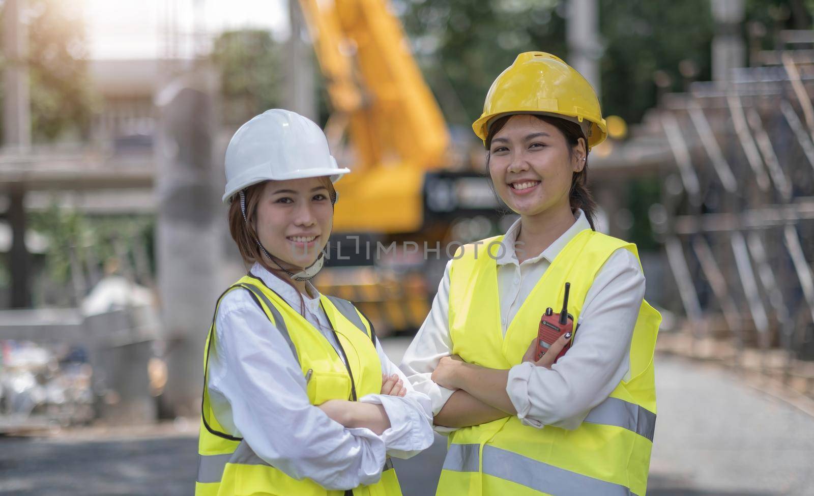 Female construction engineer. Portrait of a young woman working at a construction site. by wichayada