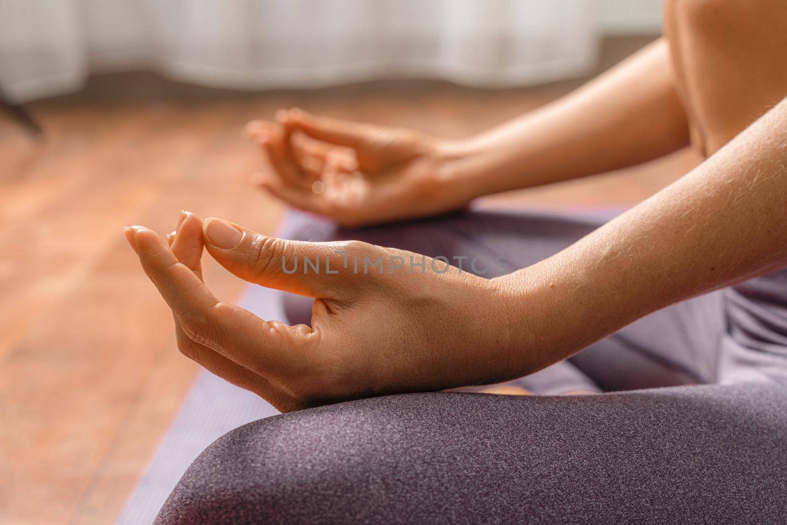 Young woman meditating in the lotus pose at home. Practicing yoga indoors. Harmony, yoga practice, balance, meditation, relaxation at home, healthy lifestyle concept