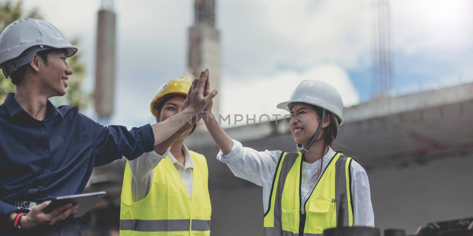 Asian engineers and architects at the construction site teamwork engineer work togetheSuccessful teamwork housing project by wichayada