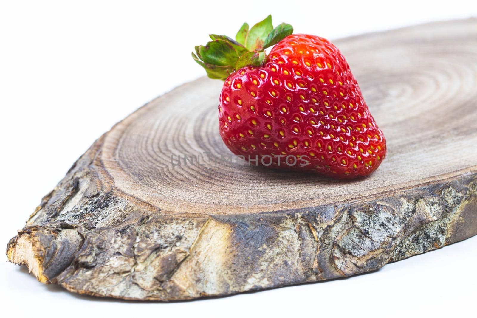 Red ripe strawberry lies on a wooden background. High quality photo