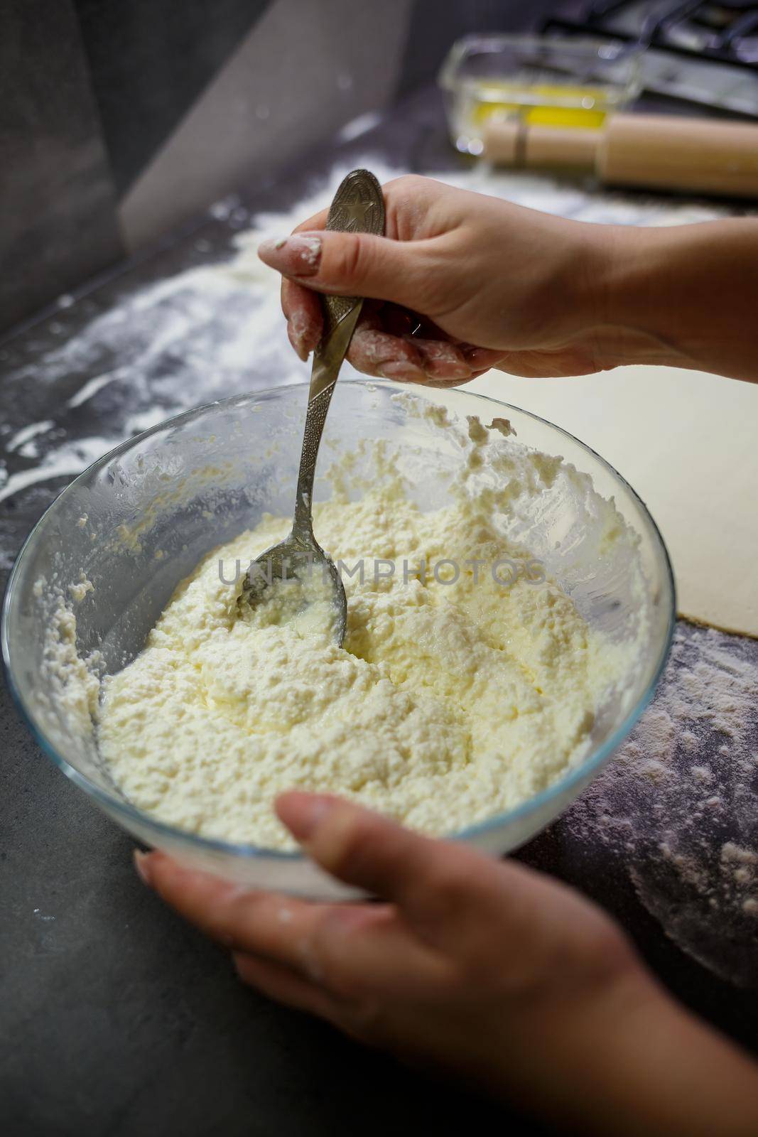 Baking domestic rolls with cheese. Putting cheese on dough for rolls