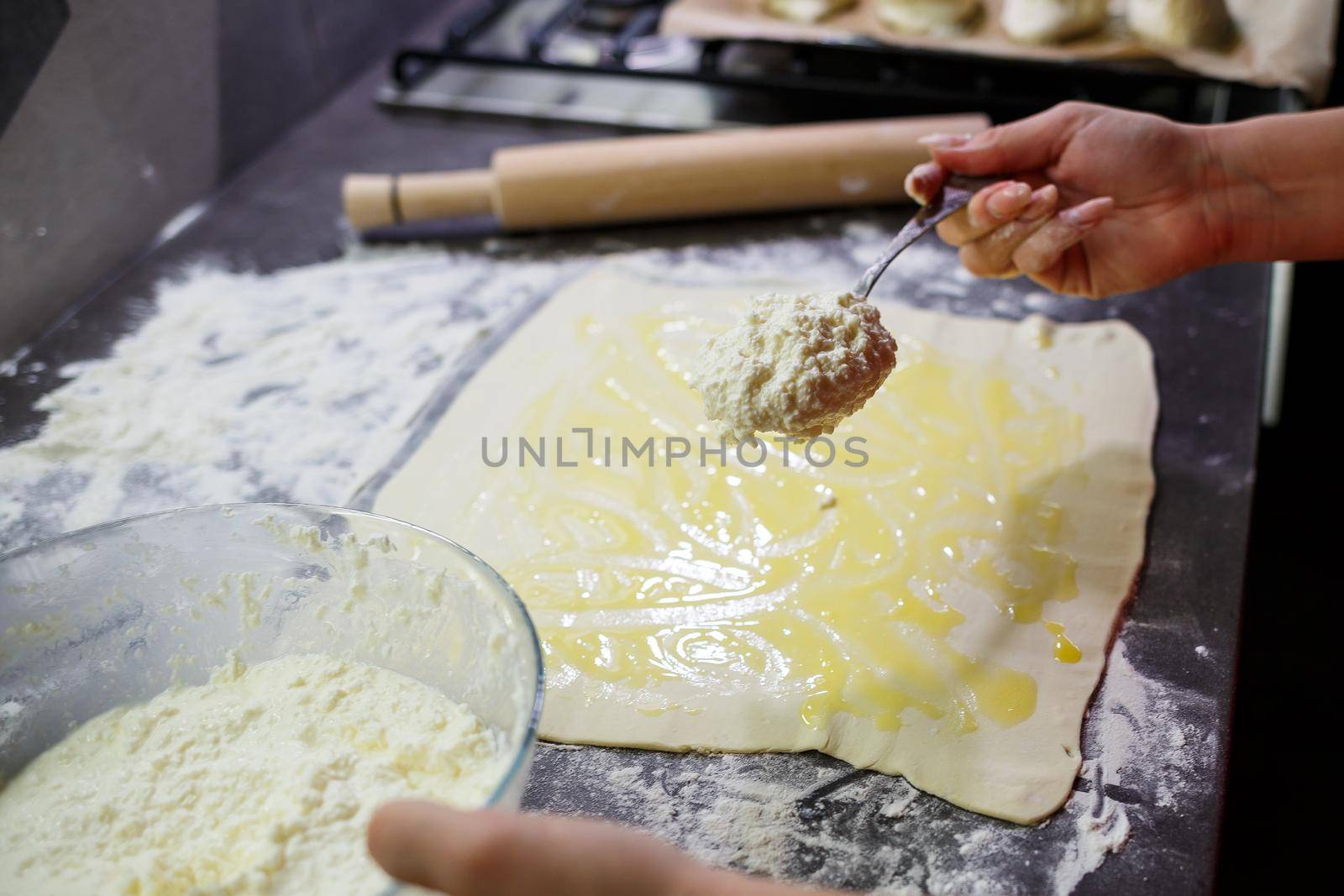 Baking domestic rolls with cheese. Putting cheese on dough for rolls