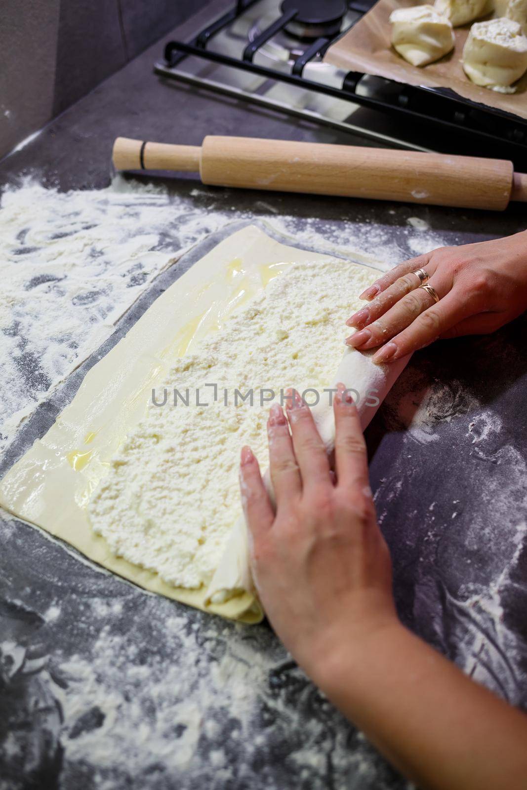 Baking domestic rolls with cheese. Putting cheese on dough for rolls