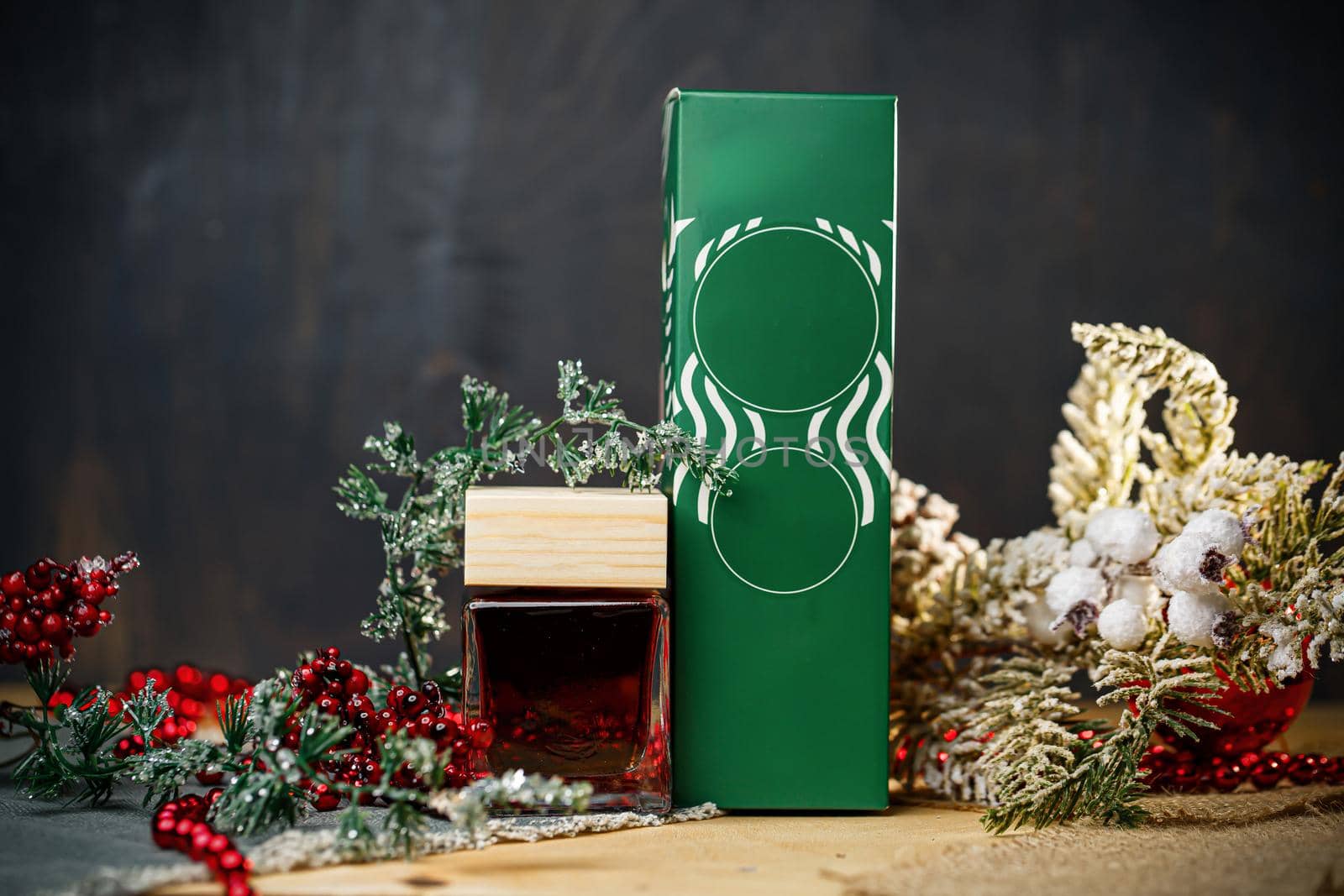 Perfume bottle New Year's gift. Stylish New Year decor perfume bottle is under the tree. Fashionable perfumes in New Year's locations. Perfumes for women