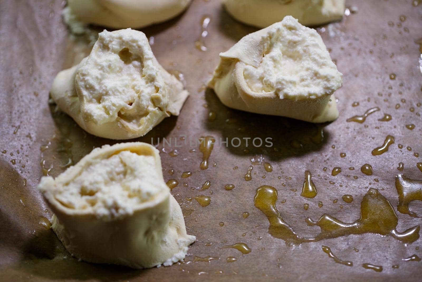 Baking domestic rolls with cheese. Putting cheese on dough for rolls