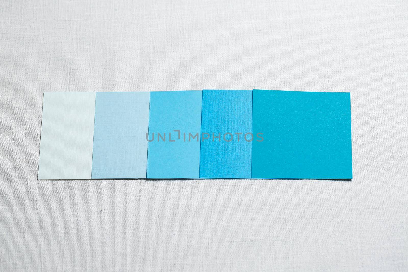 square pieces of multi-colored fabric laid out on a gray background