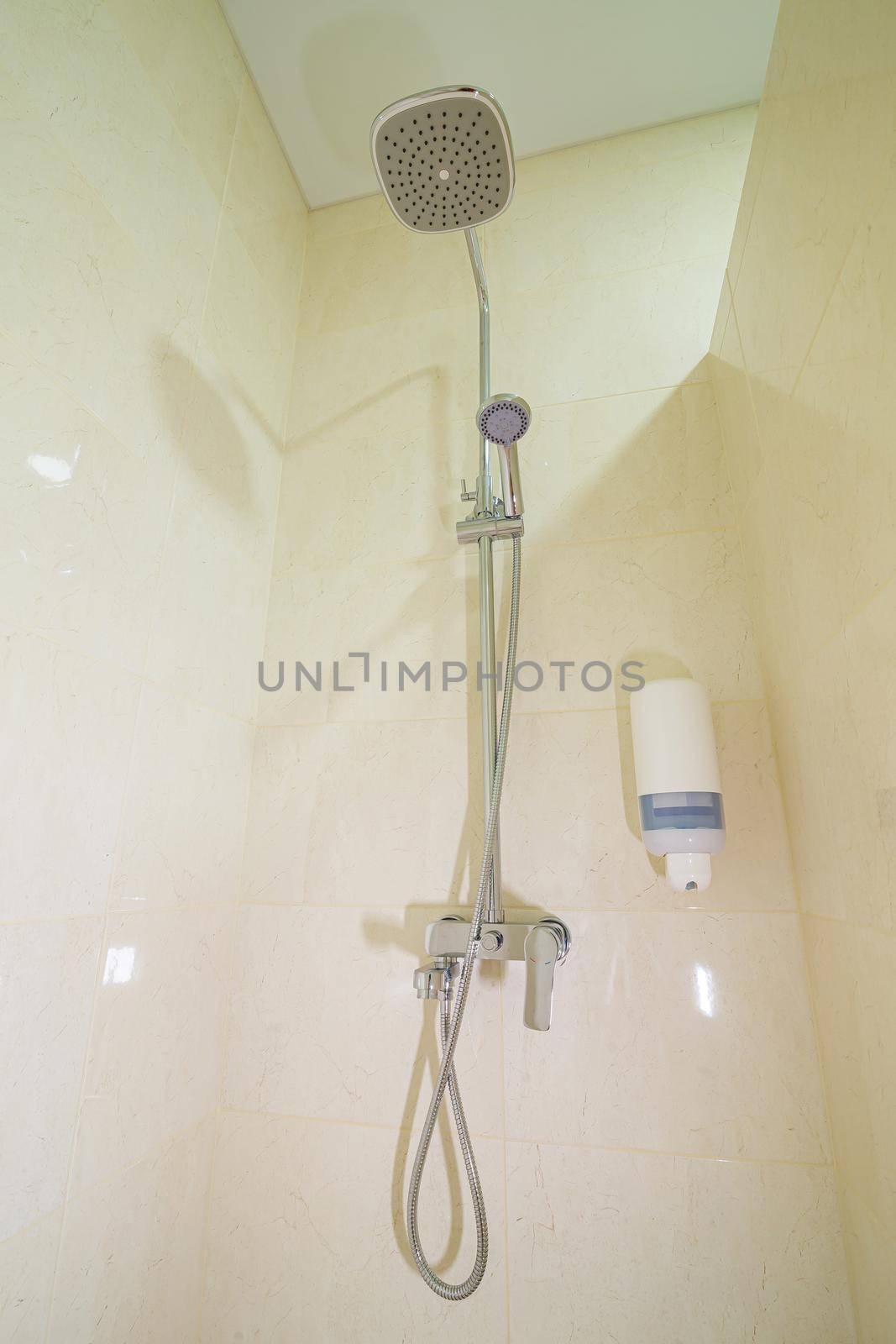 Bright bathroom with shower, shower head, light tile