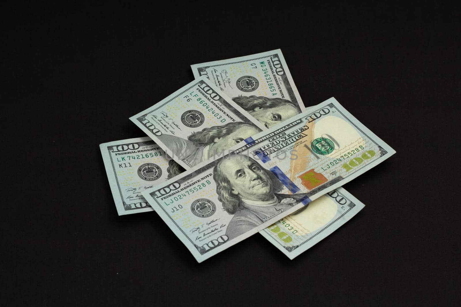 American cash money, banknotes four hundred us dollars on black background, one hundred dollar bills in stack